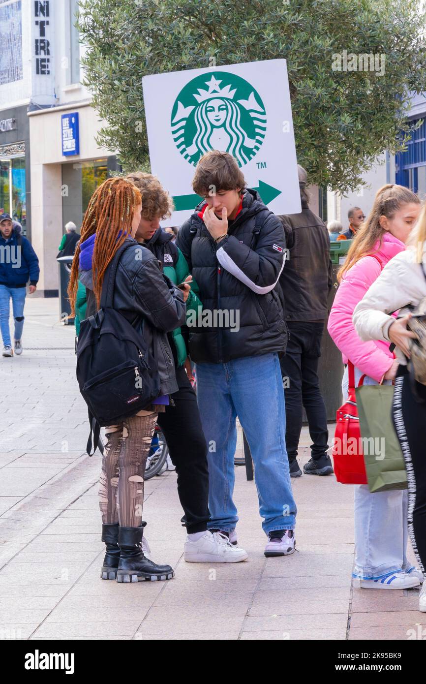 Irland Irland Irland Dublin Grafton Street Straßenszene Teenager Goth Mädchen zerrissene Strumpfhosen Stiefel Dreadlocks Starbucks Schild Plakat plaudern Freizeit Freunde Stockfoto