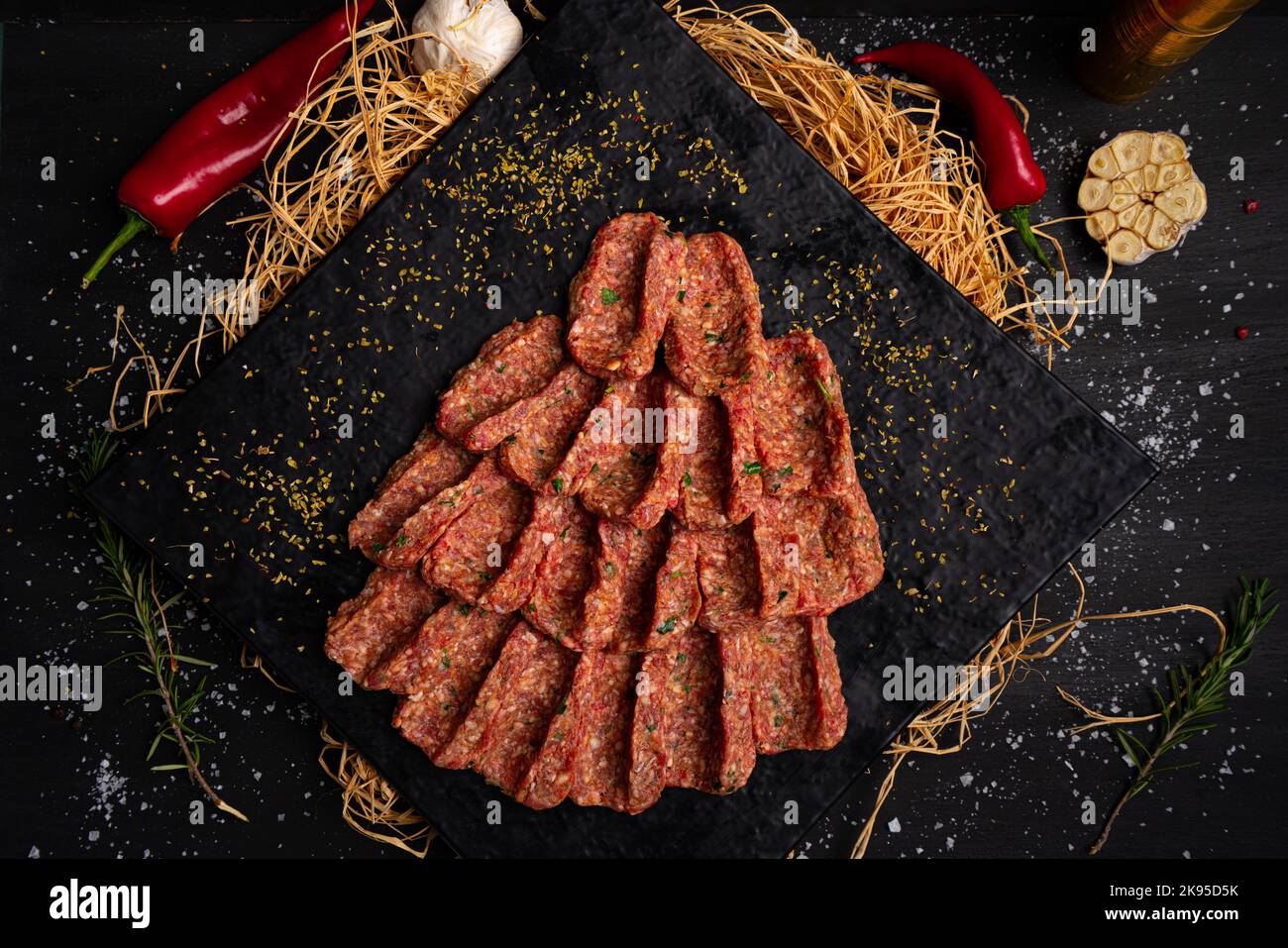 Rohes Hackfleisch auf schwarzem Steinteller. Geformtes Hackfleisch Stockfoto