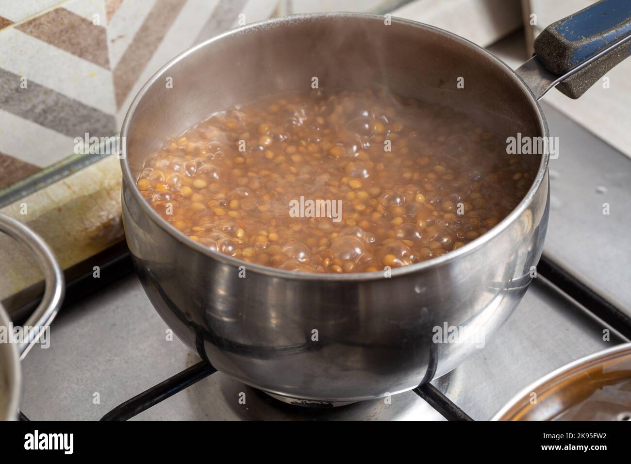 Linsen in der Schüssel auf dem Herd Stockfoto