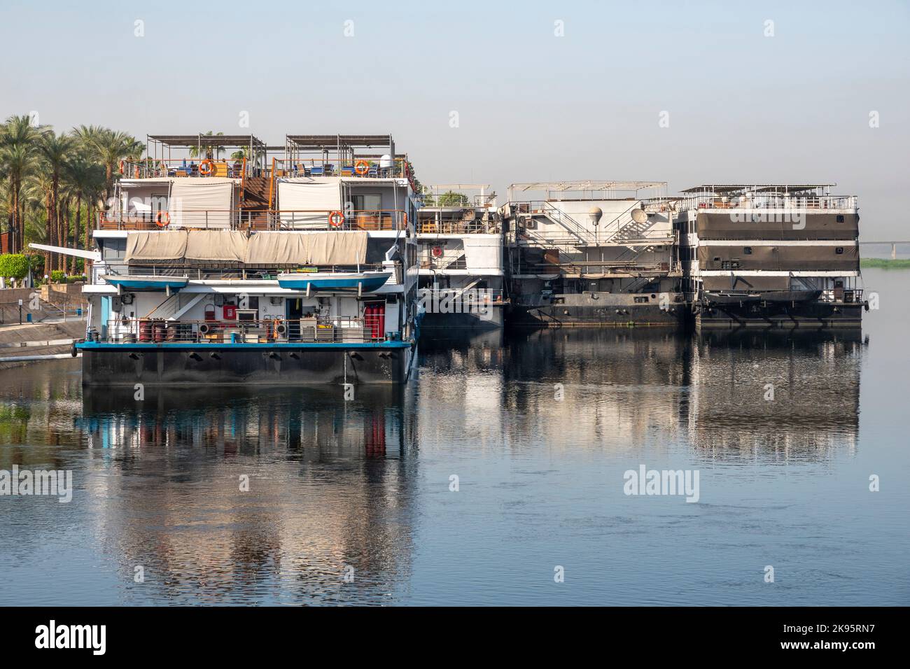 Fernaufnahme des hinteren Endes der Nilkreuzfahrtschiffe, die sich im Nil spiegeln Stockfoto