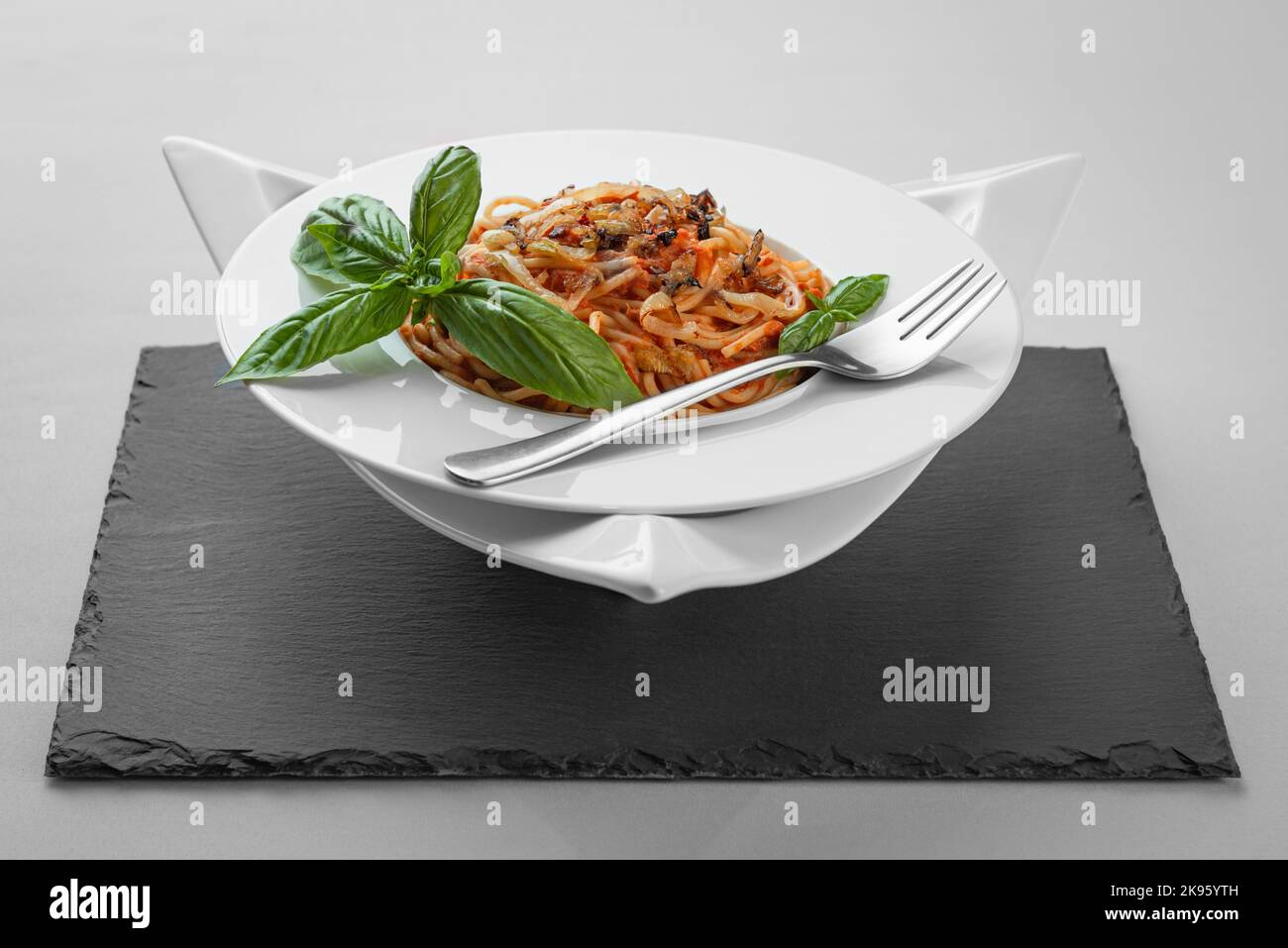 Spaghetti Thunfisch Pasta Basilikum Platte Dreieck Form Schiefertisch ziemlich appetitlich Stockfoto