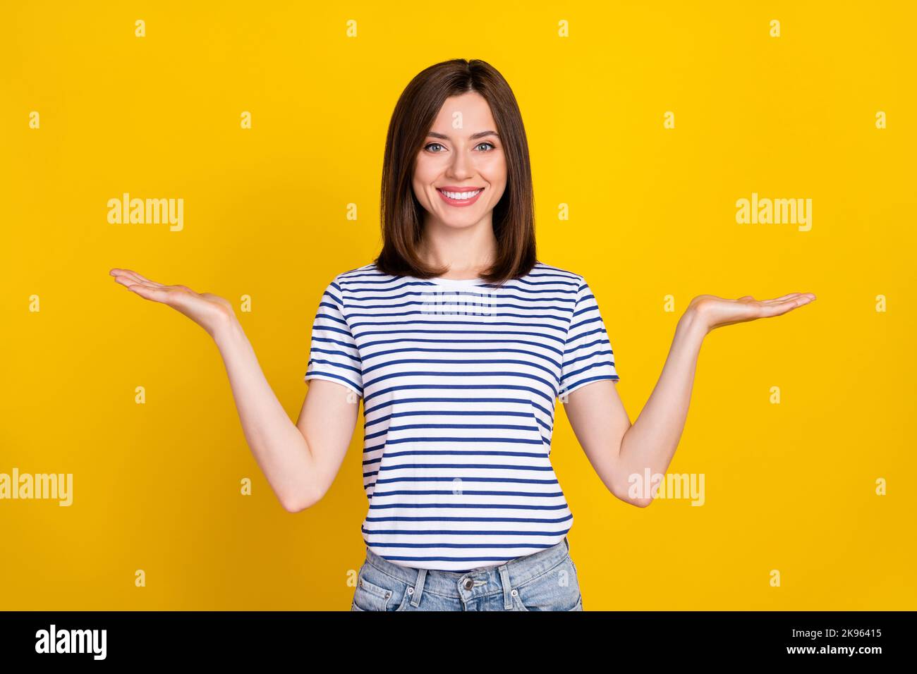 Portrait Foto von jungen attraktiven Frau halten Palmen vergleichen verschiedene Produkte Profis isoliert auf gelbem Hintergrund Stockfoto