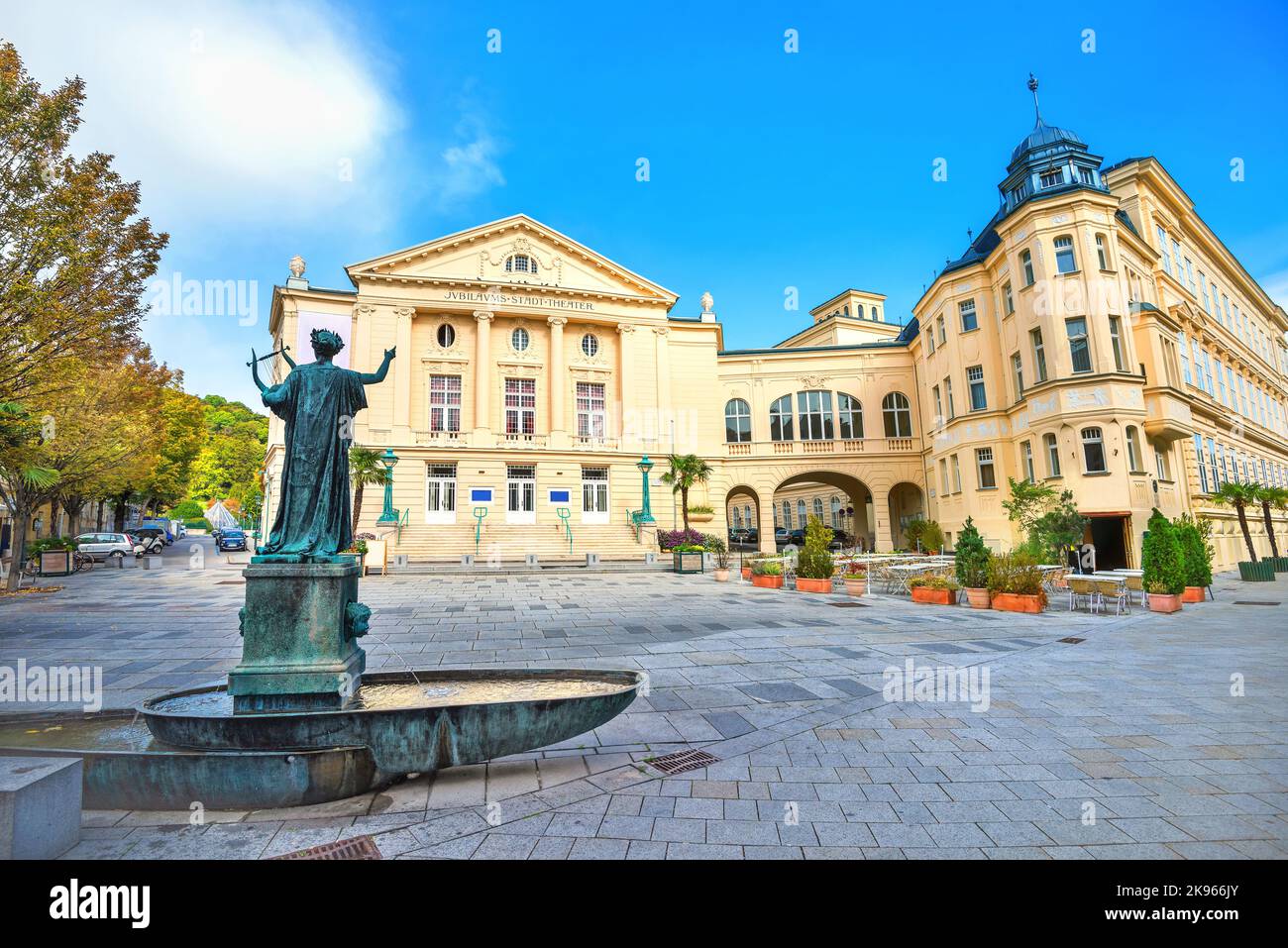 Ansicht des Theatergebäudes und der Kunstskulptur mit kleinem Brunnen auf dem Stadtplatz in Baden bei Wien. Österreich Stockfoto