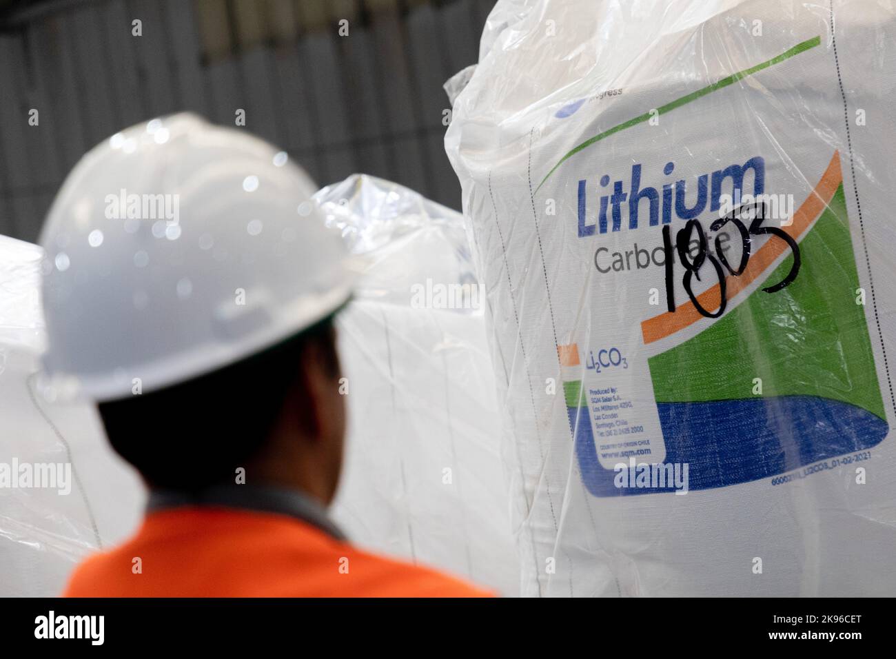 Antofagasta, Chile. 25. Oktober 2022. Ein Arbeiter steht vor einem Beutel mit Lithiumcarbonat in einem Lager des chilenischen Unternehmens SQM, in dem Lithium aus der Atacama-Wüste verarbeitet wird. Kredit: Lucas Aguayo Araos/dpa/Alamy Live Nachrichten Stockfoto