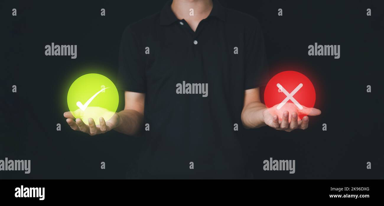 Überprüfen Sie die grüne Markierung und das rote falsche Symbol im Kreis auf der Hand des Geschäftsmanns. Abstimmung stornieren oder genehmigt. Antwortkonzept. Korrigieren und kreuzen. Stockfoto