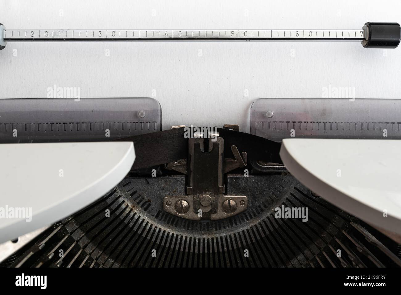 Nahaufnahme von leerem weißem Papier mit Kopierplatz in alter mechanischer Schreibmaschine Stockfoto