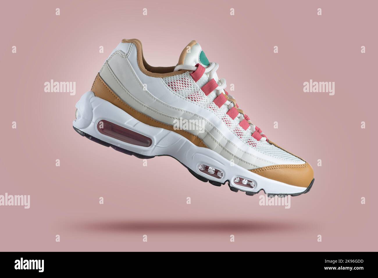 Weißer Sneaker mit farbigen Akzenten auf einem rosa Hintergrund, Mode, Sportschuh, Air, Sneaker, Lifestyle, Konzept, Produktfoto, Levitation Stockfoto