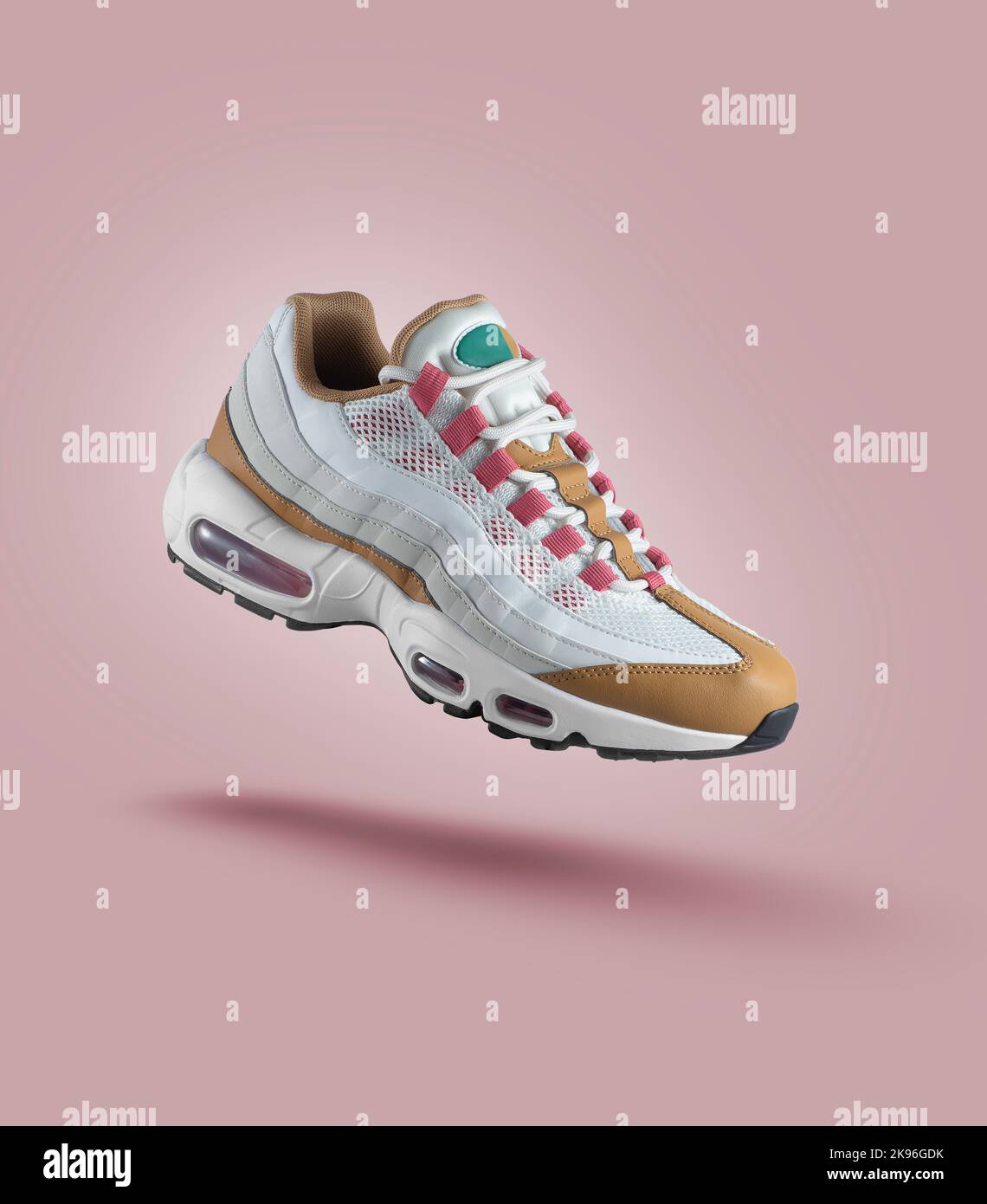 Weißer Sneaker mit farbigen Akzenten auf einem rosa Hintergrund, Mode, Sportschuh, Air, Sneaker, Lifestyle, Konzept, Produktfoto, Levitation Stockfoto