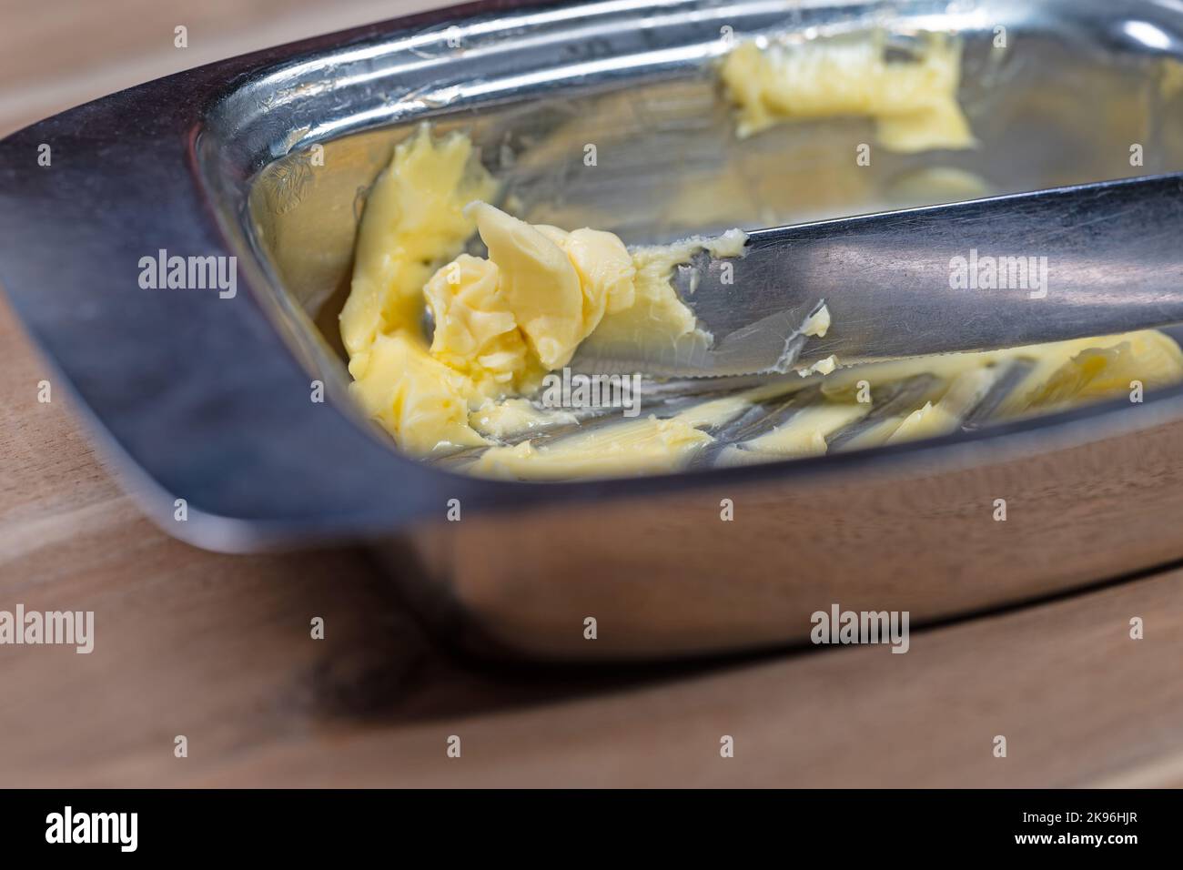 Butter und Messer in die Butterdose geben Stockfoto