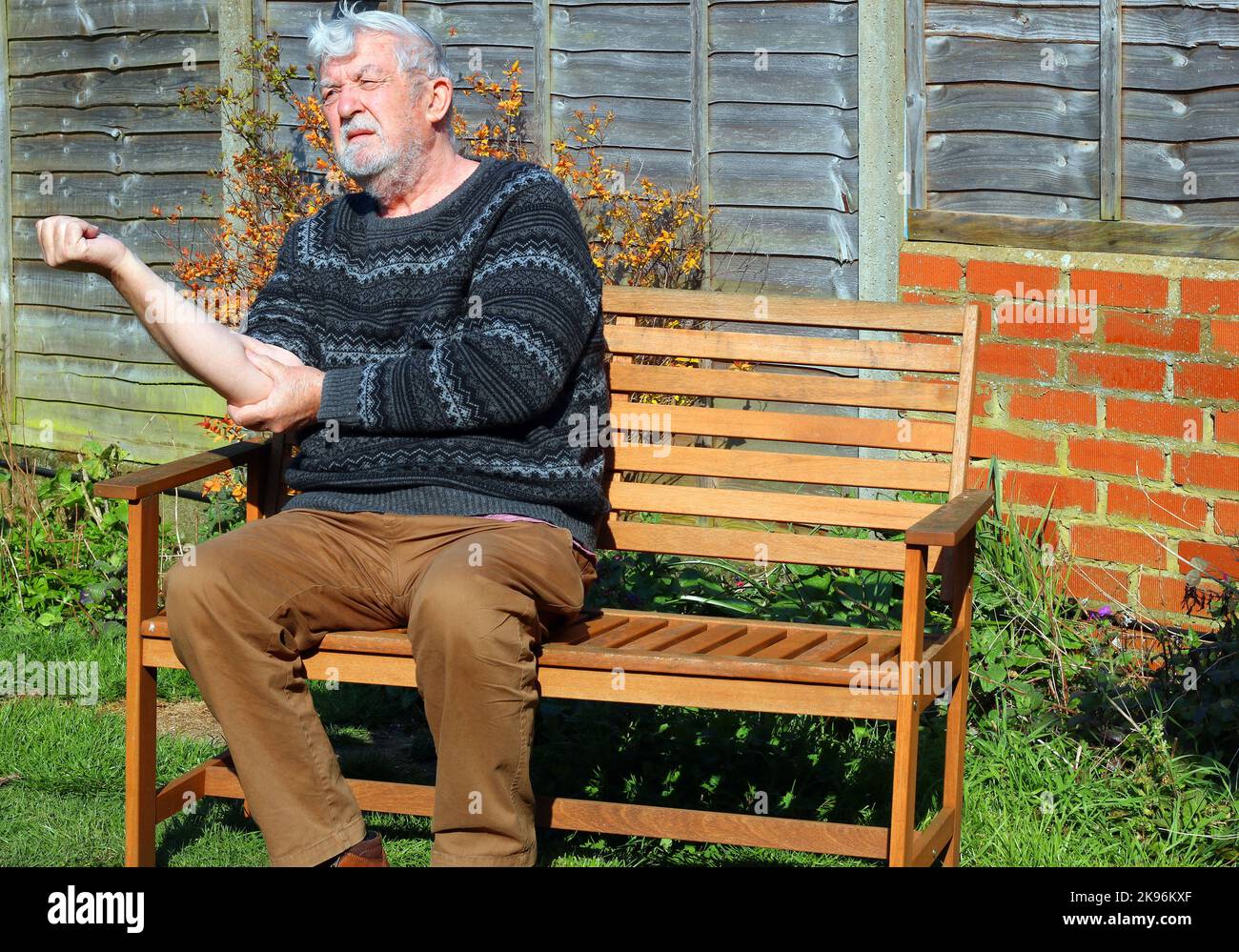 Älterer oder älterer Mann mit Schmerzen, der an Arthritis des Ellenbogens und Armes leidet. Stockfoto