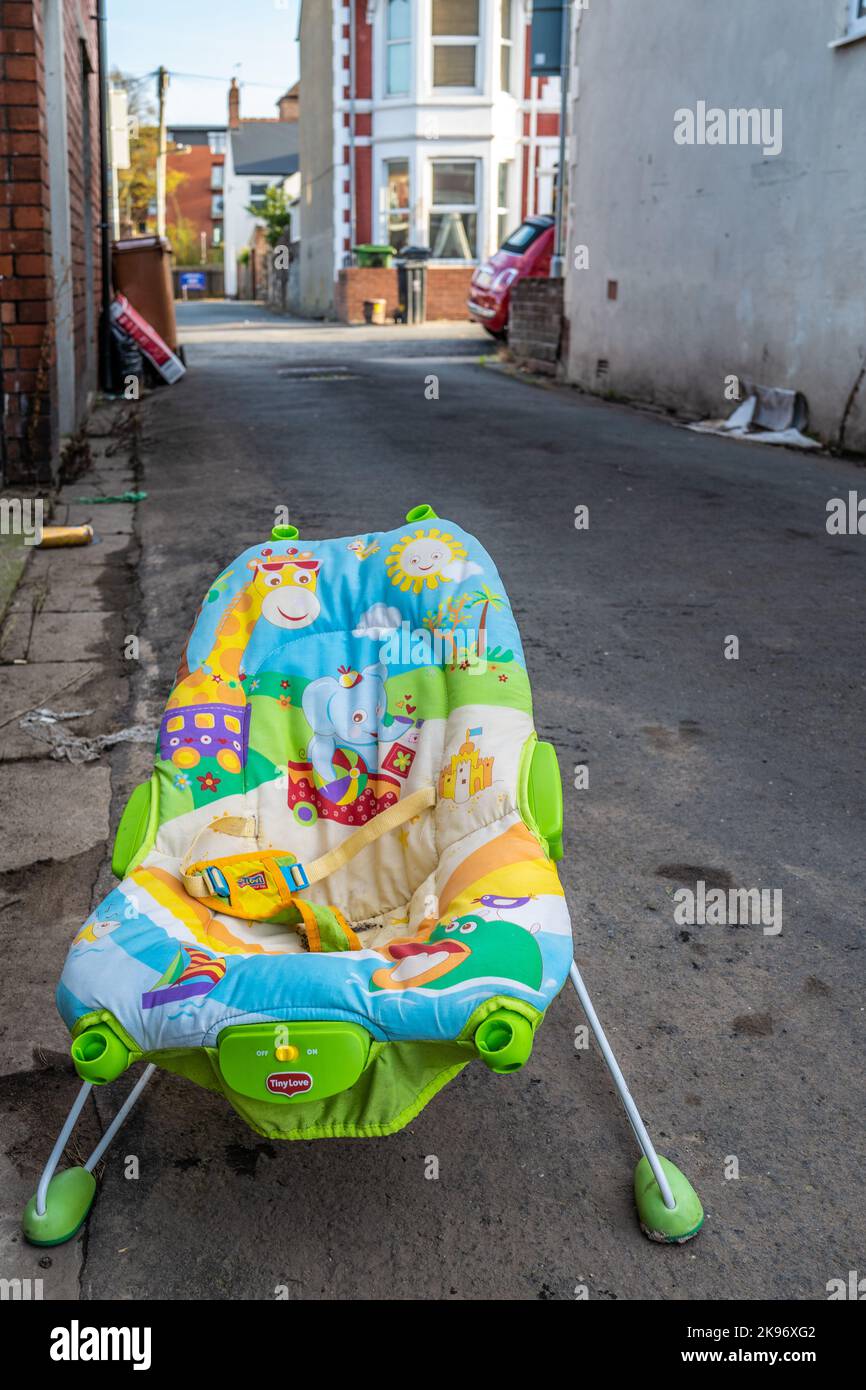 Tragbarer Baby-Schaukelstuhl, der illegal als Fliegenkippen in einer Seitenstraße in Cardiff, Großbritannien, verworfen wurde Stockfoto