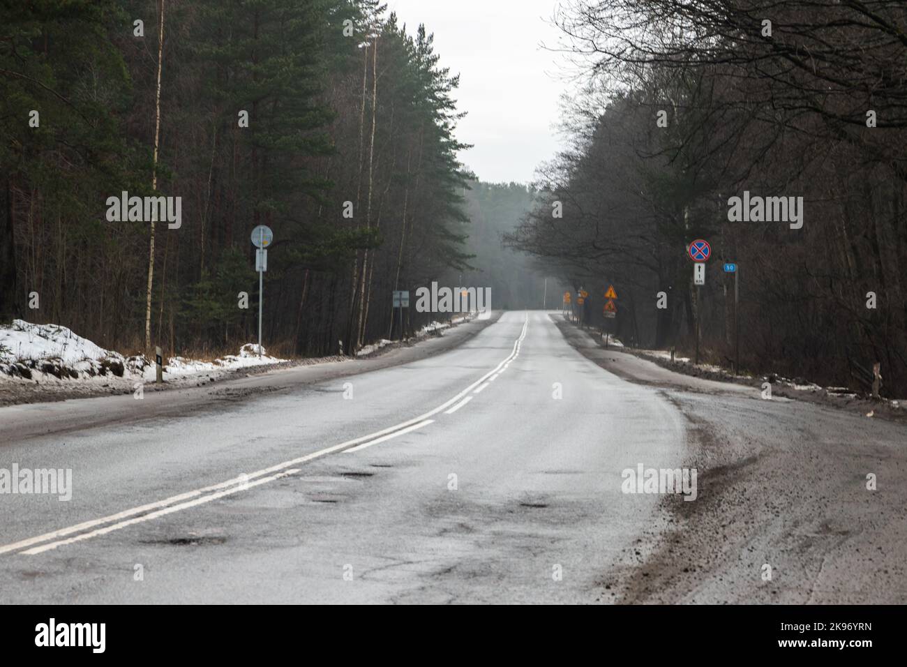 Nasse Landstraße an einem nebligen Tag, Reisehintergrundfoto, Blick auf die Autobahn in der Wintersaison Stockfoto