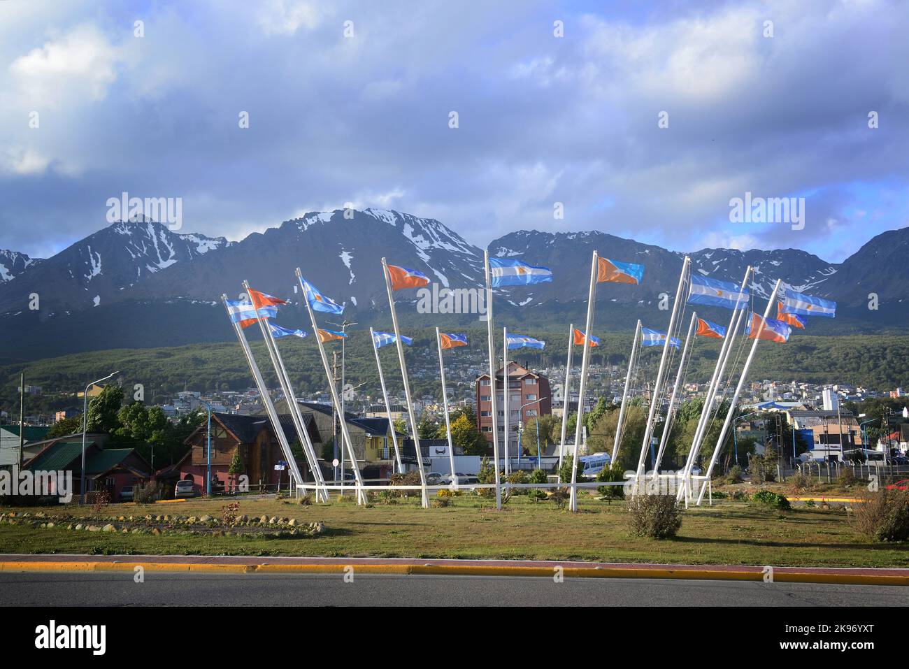 Die lange Aufnahme von Ushuaia und die Flaggen von Argentinien und Ushuaia in einem Kreis angeordnet, mit schneebedeckten Gipfeln des Berges Olivia im Hintergrund Stockfoto