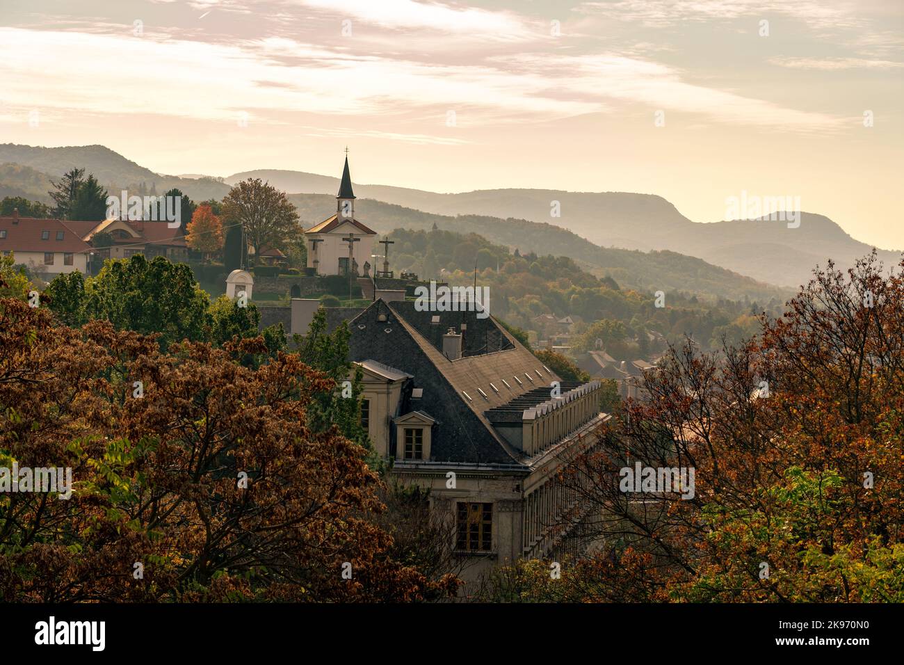 Nebeliger Morgen über Esztergom mit kleiner Kapelle und Berghügeln im Hintergrund Stockfoto