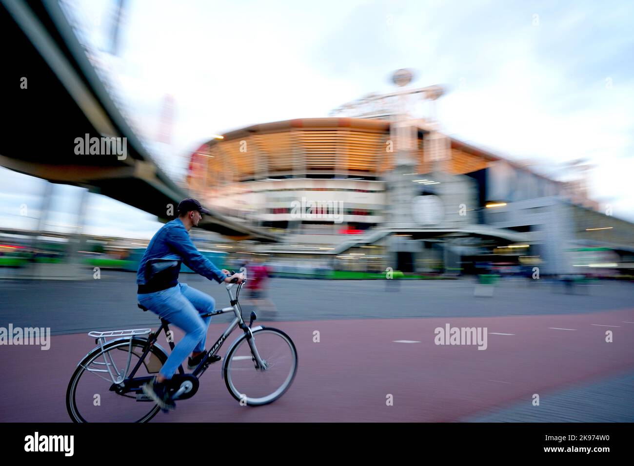 Ein Radfahrer passiert das Stadion vor dem Spiel der UEFA Champions League-Gruppe A in der Johan Cruyff Arena in Amsterdam, Niederlande. Bilddatum: Mittwoch, 26. Oktober 2022. Stockfoto