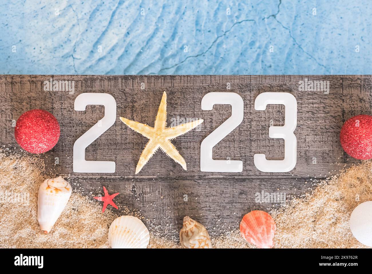 Frohes neues Jahr 2023 Konzept mit einer Schale und einem Seestern am Pool. Winterurlaub in der Sonne. Stockfoto