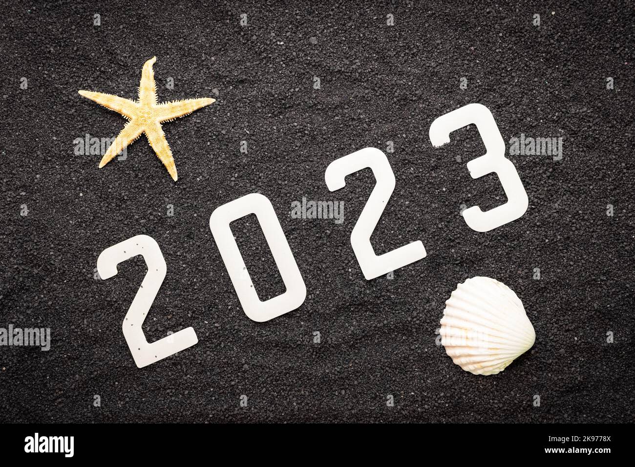 Frohes neues Jahr 2023 Konzept mit einer Schale und einem Seesterne. Winterurlaub in der Sonne. Stockfoto