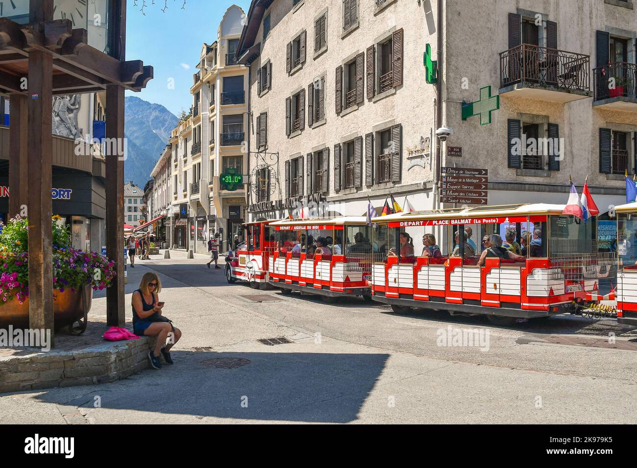 Der rote kleine Zug, der die Alpenstadt im Sommer mit Touristen beladen durchquert, Chamonix, Haute Savoie, Frankreich Stockfoto