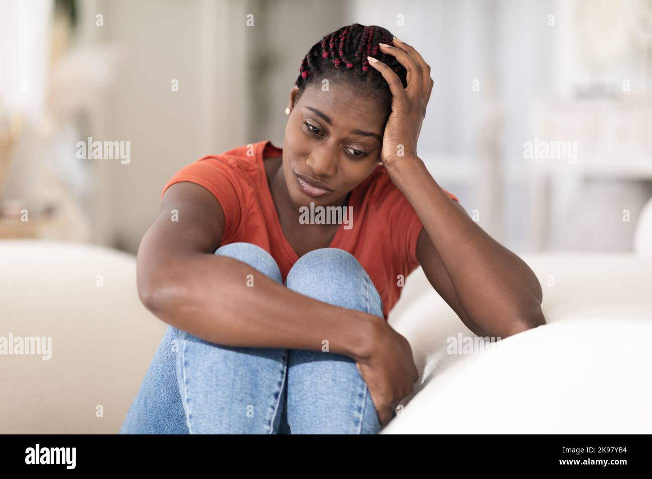 Porträt Einer Depressiven Jungen Schwarzen Frau, Die Zu Hause Auf Der Couch Sitzt Stockfoto
