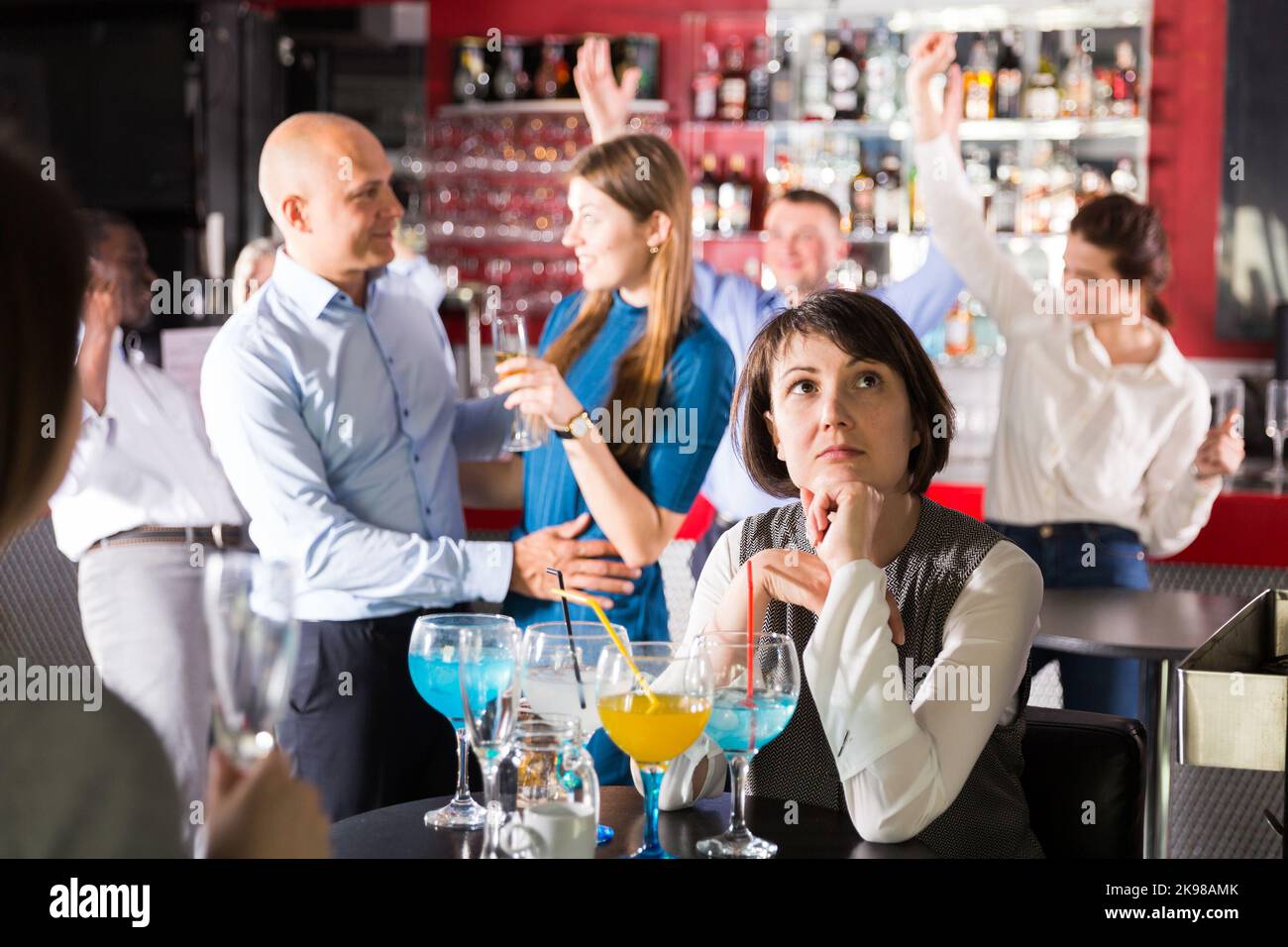 Gelangweilte Frau auf der Firmenfeier Stockfoto