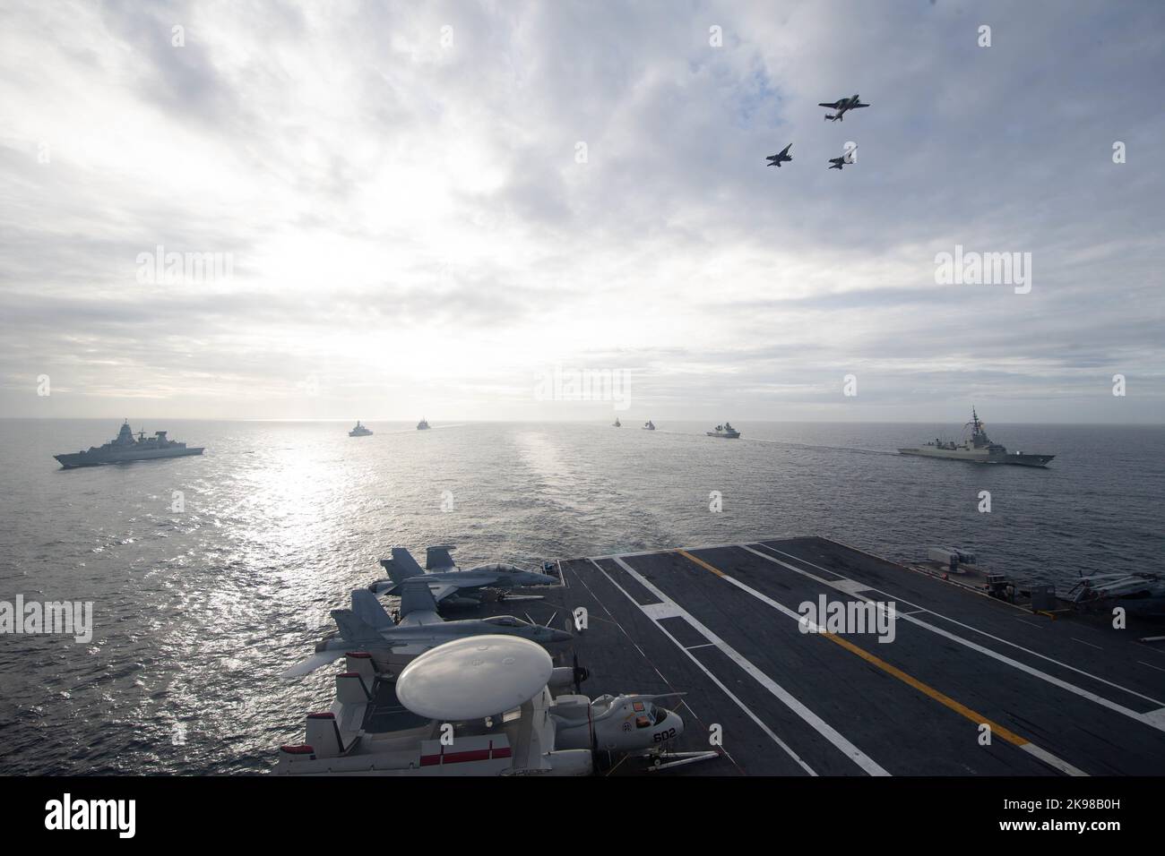 An Carrier Air Wing (CVW) 8 angeschlossene Flugzeuge fliegen über den erstklassigen Flugzeugträger USS Gerald R. Ford (CVN 78), während das Schiff in Formation mit der spanischen Armada Fregatte Álvaro de Bazán (F 101), der dänischen Fregatte HDMS Peter Willemoes (F362), der niederländischen Fregatte HNLMS De Zeven Provincien (F 802) dampft, Arleigh Burke-Klasse, USS Ramage (DDG 61), die deutsche Fregatte FGS Hessen (F 221), die niederländische Fregatte HNLMS Van Amstel (F 831) und der Ticonderoga-Klasse, USS Normandy (CG 60), 25. Oktober 2022. Die Gerald R. Ford Carrier Strike Group (GRFCSG) wird im Atlantic OCE eingesetzt Stockfoto