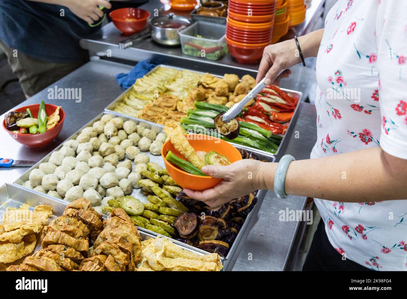 Menschen, die yong Tau foo, köstliche frittierte gefüllte Fischpaste in Chili, Okra, Aubergine, Bohnenpaste und andere Sorten auswählen. Stockfoto