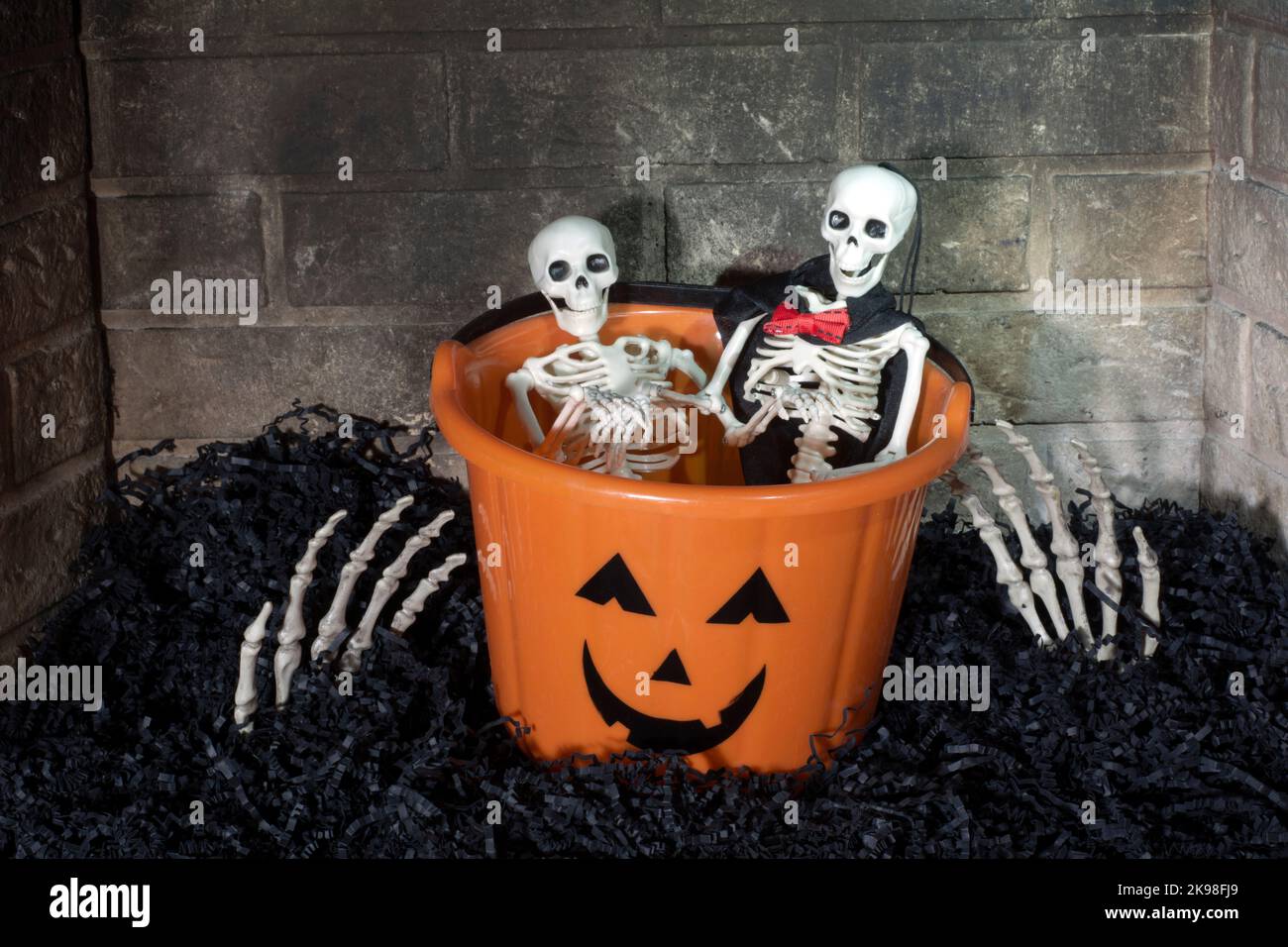 Kamin-Szene mit Skelett Hände nach Halloween-Korb mit zwei Skelette im Inneren greifen Stockfoto