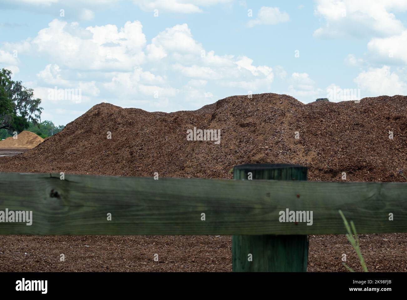 Ein großer industrieller Vorrat aus abgebroschter Rinde aus rauem Holz und Holzspännen. Das zerfetzte Kompost-Produkt aus recyceltem organischem Material. Stockfoto