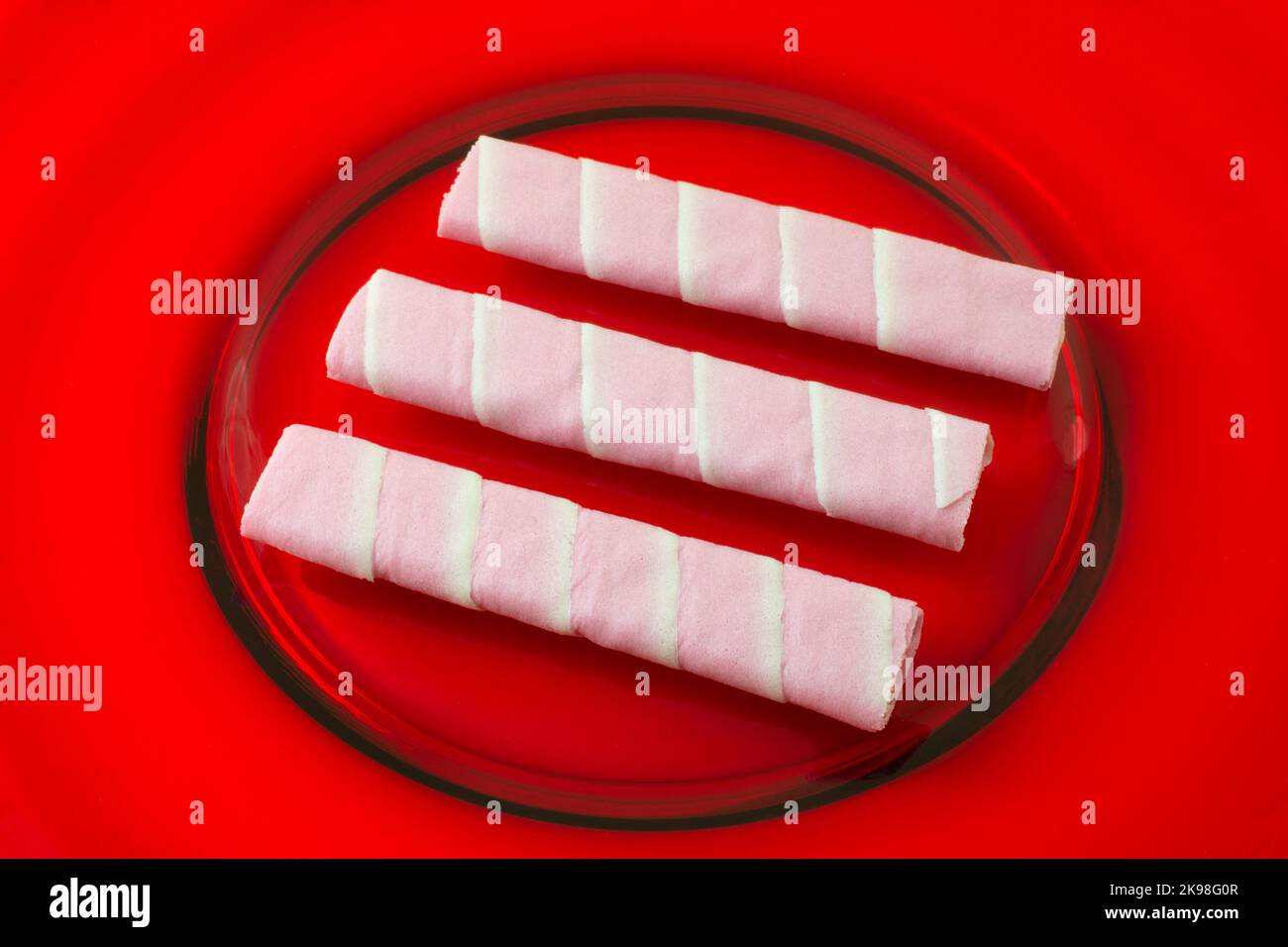 Drei Kirschblüten-Crepe-Kekse auf rotem Glasplatte Stockfoto