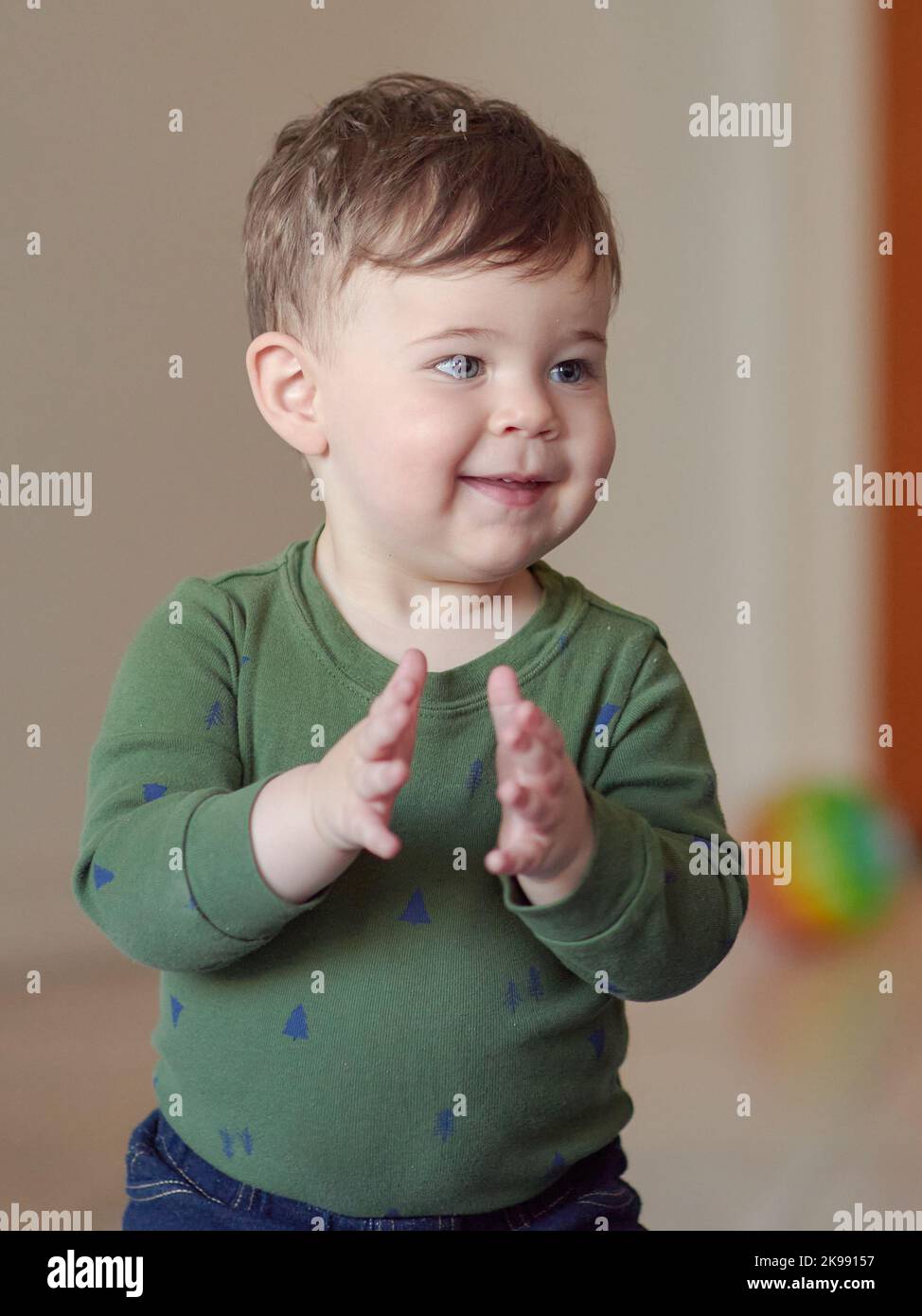 Niedliches Kleinkind klatscht zu Hause in die Hände Stockfoto