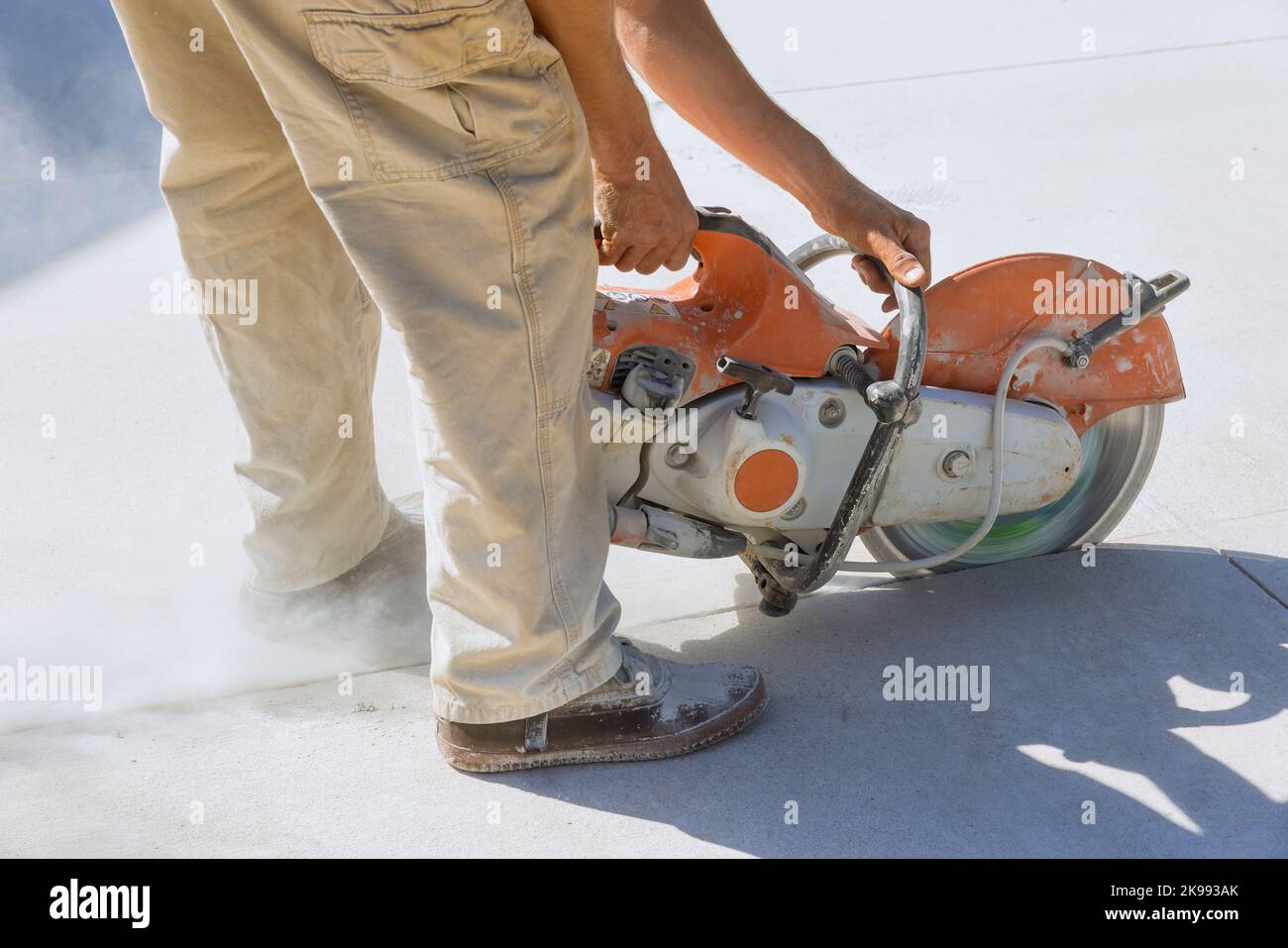 Dies ist der Bauarbeiter, der Betonplatten für Gehwege mit einer abgetrennten Diamant-Säge schneidet. Stockfoto