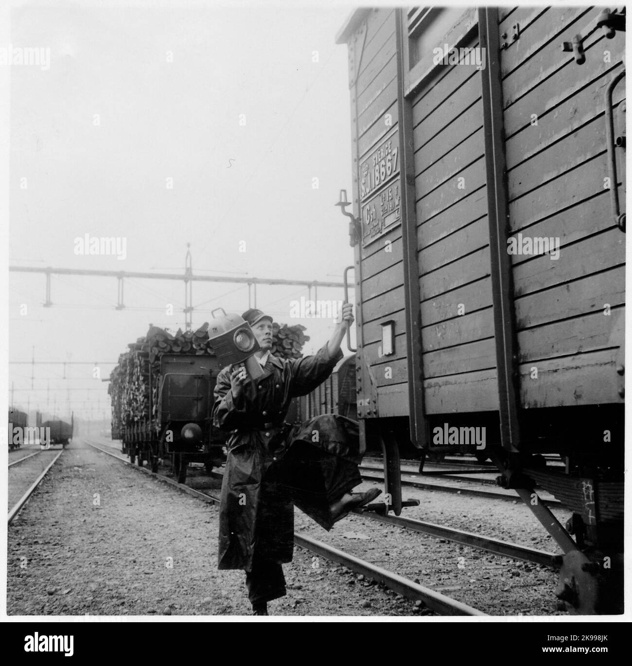 Train Master G.olsson mit einem letzten Schild am Güterwagen. Ältere Platzierung der Laterne auf dem Wagen. Güterverkehr, Staatsbahnen, SJ GSH 18667. Stockfoto