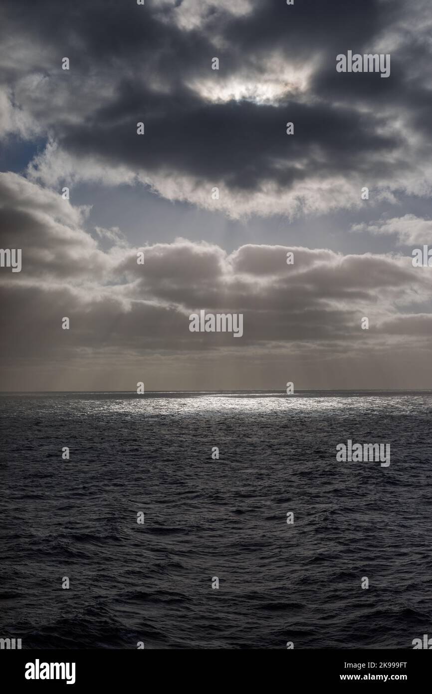 Sonnenlicht bricht durch die Wolken mitten im Ozean Stockfoto