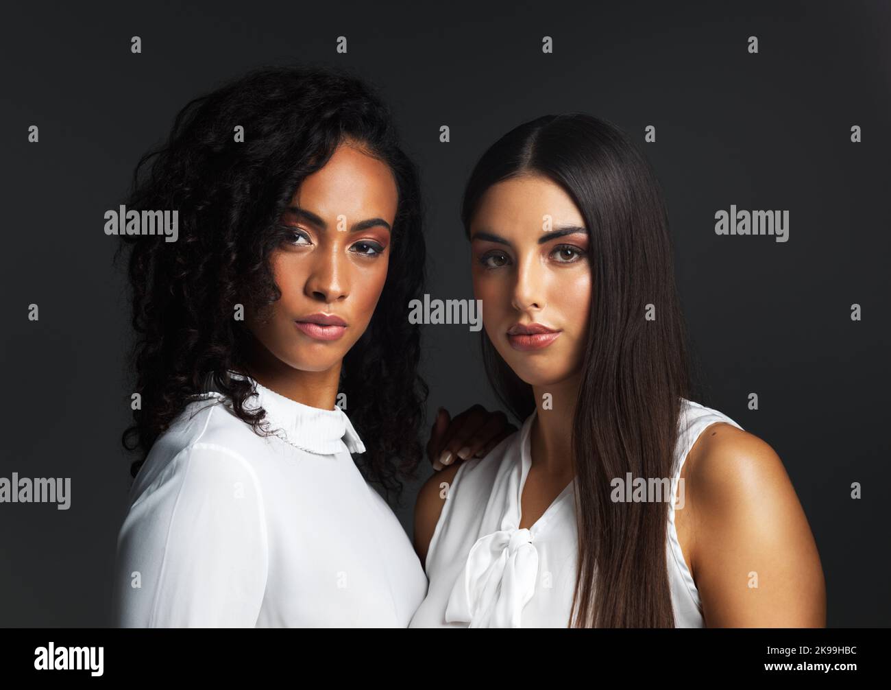 Das schönste, was eine Frau tragen kann, ist Vertrauen. Porträt zweier attraktiver junger Frauen in weißen Blusen, die eng miteinander posieren Stockfoto