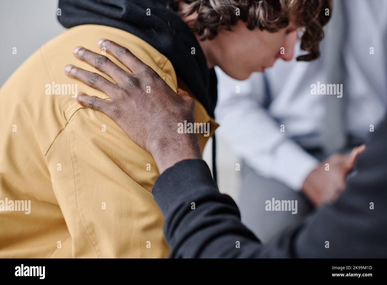 Deprimierter Teenager, der Unterstützung von anderen Menschen bekommt, während er einen Psychologen in der Klasse besucht Stockfoto