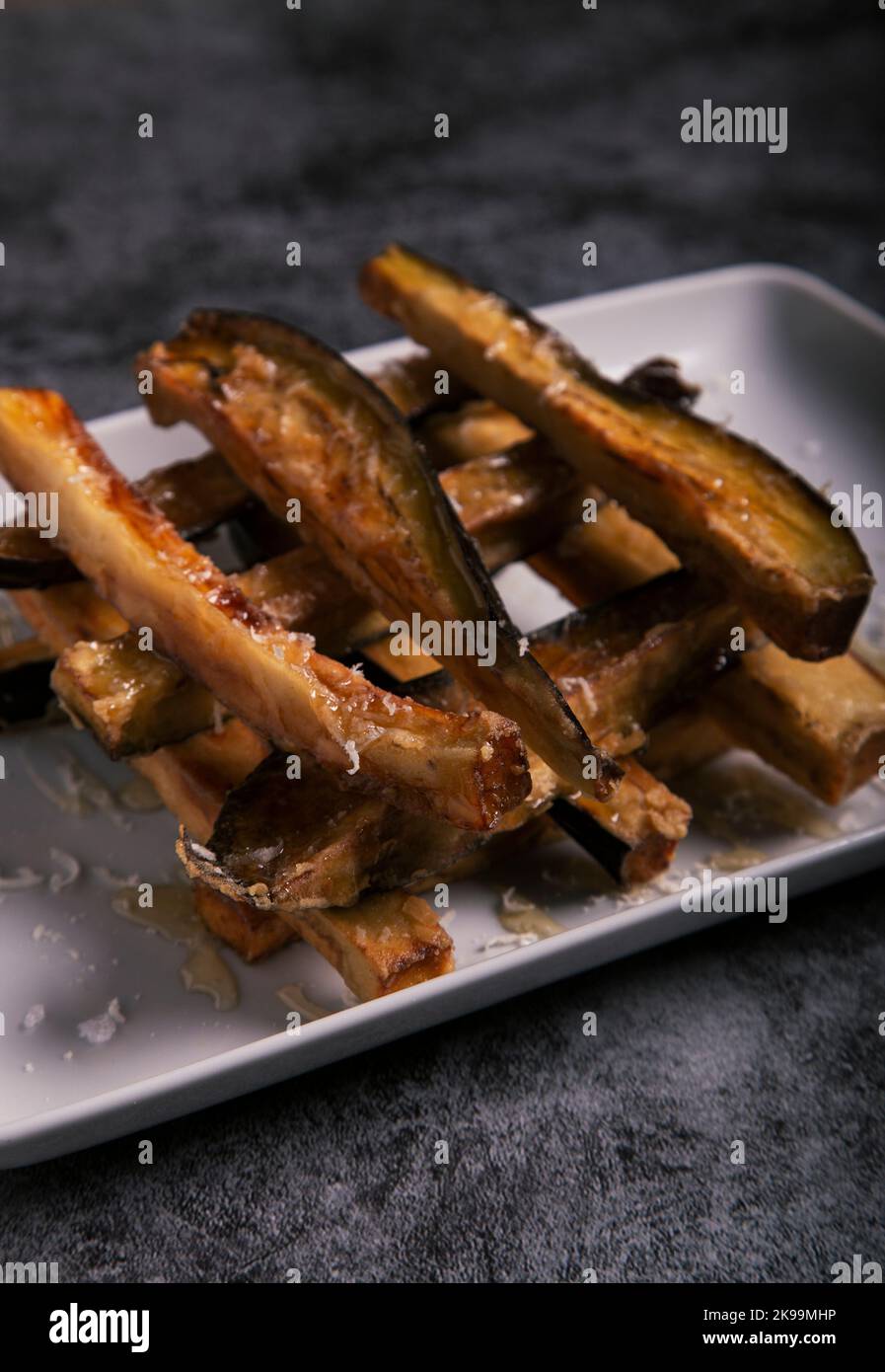 Nahaufnahme einer Auberginenplatte mit Honig.Vertikales Bild. Stockfoto