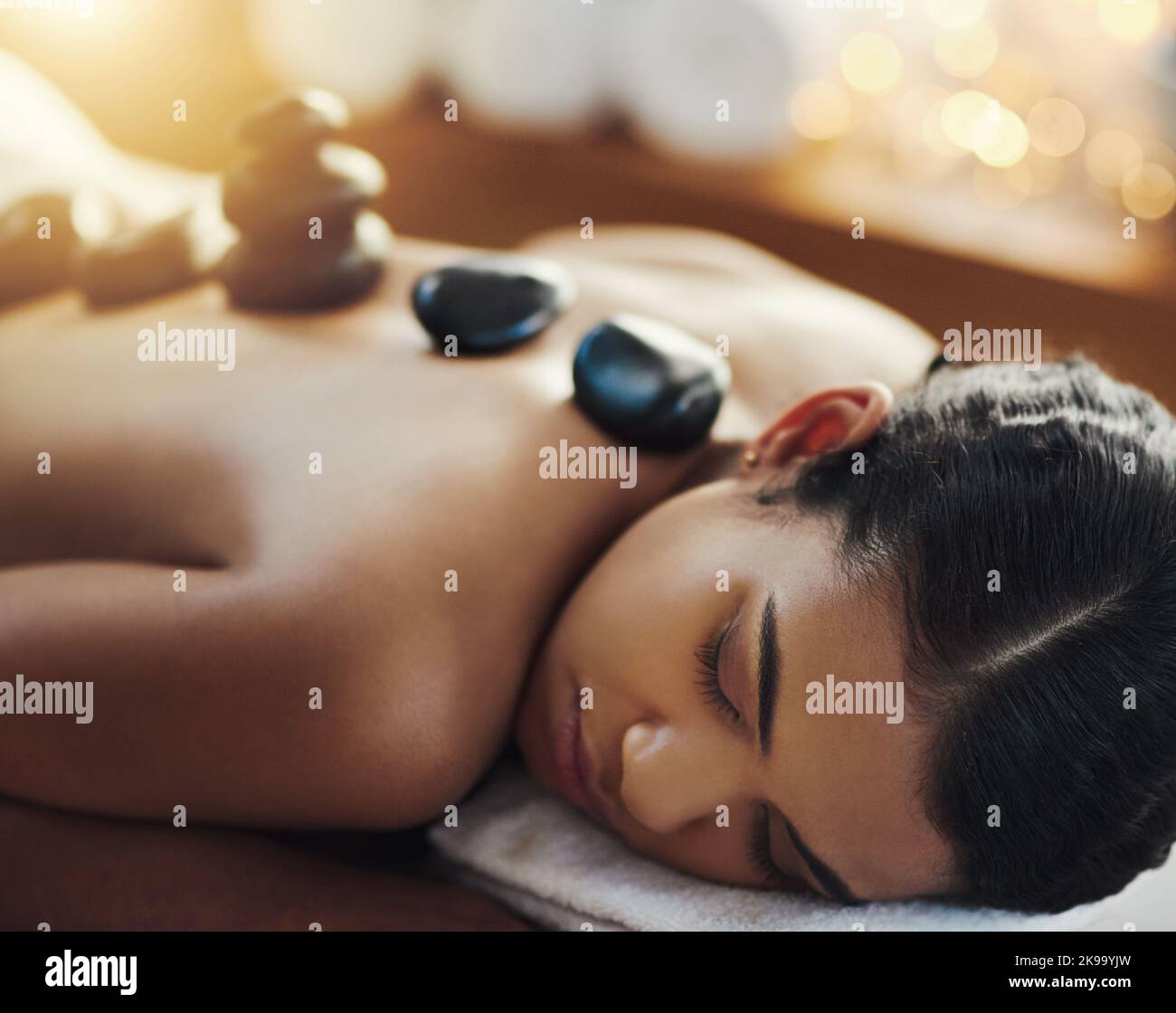 Zentriert Körper, Geist und Seele. Eine junge Frau bekommt eine Hot-Stone-Massage in einem Spa. Stockfoto