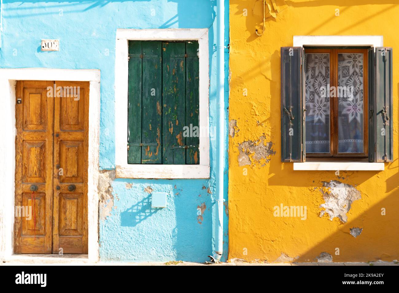 Die Wand mit Fenstern und Türen der bunten Häuser auf der Insel Burano in Venedig, Italien Stockfoto