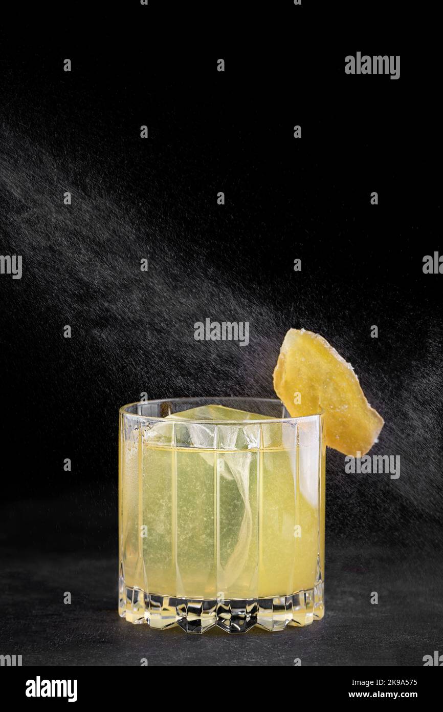 Penicillin-Cocktail in einem altmodischen Glas auf dunklem Beton Stockfoto