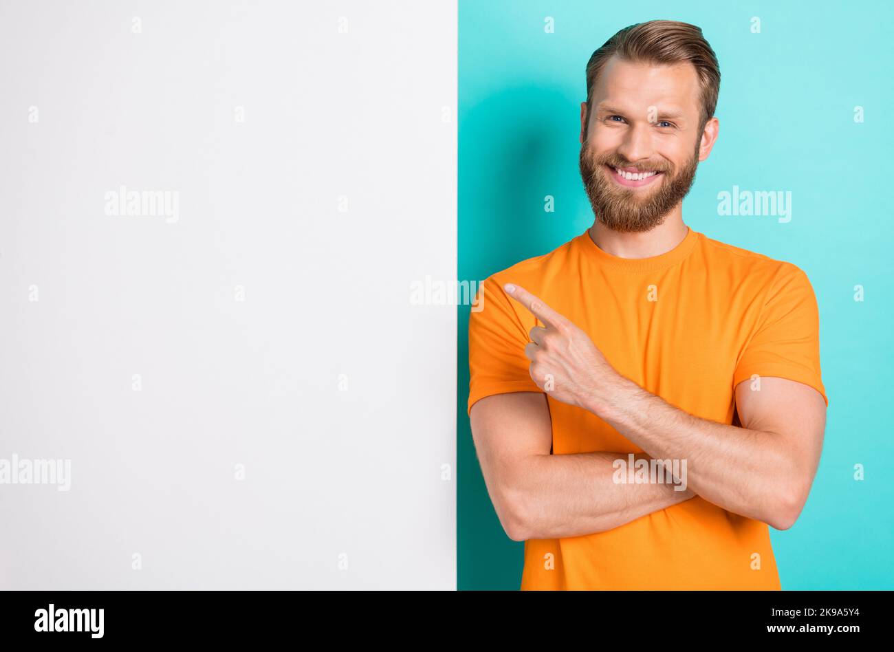 Foto von guten braunen Frisur Kerl zeigen promo tragen orange T-Shirt isoliert auf teal Farbe backgroiund Stockfoto