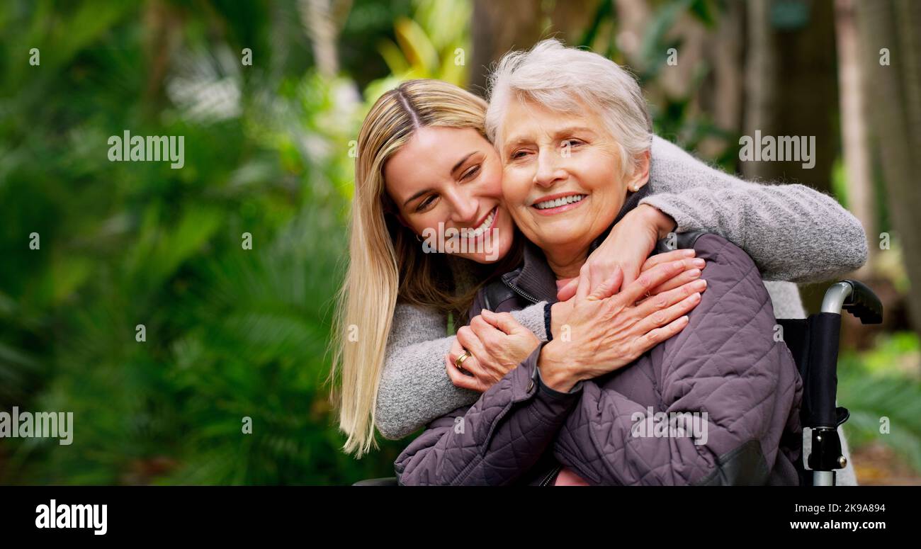 Ich liebe dich Mama. Eine fröhliche ältere Frau im Rollstuhl verbringt Zeit mit ihrer Tochter draußen in einem Park. Stockfoto