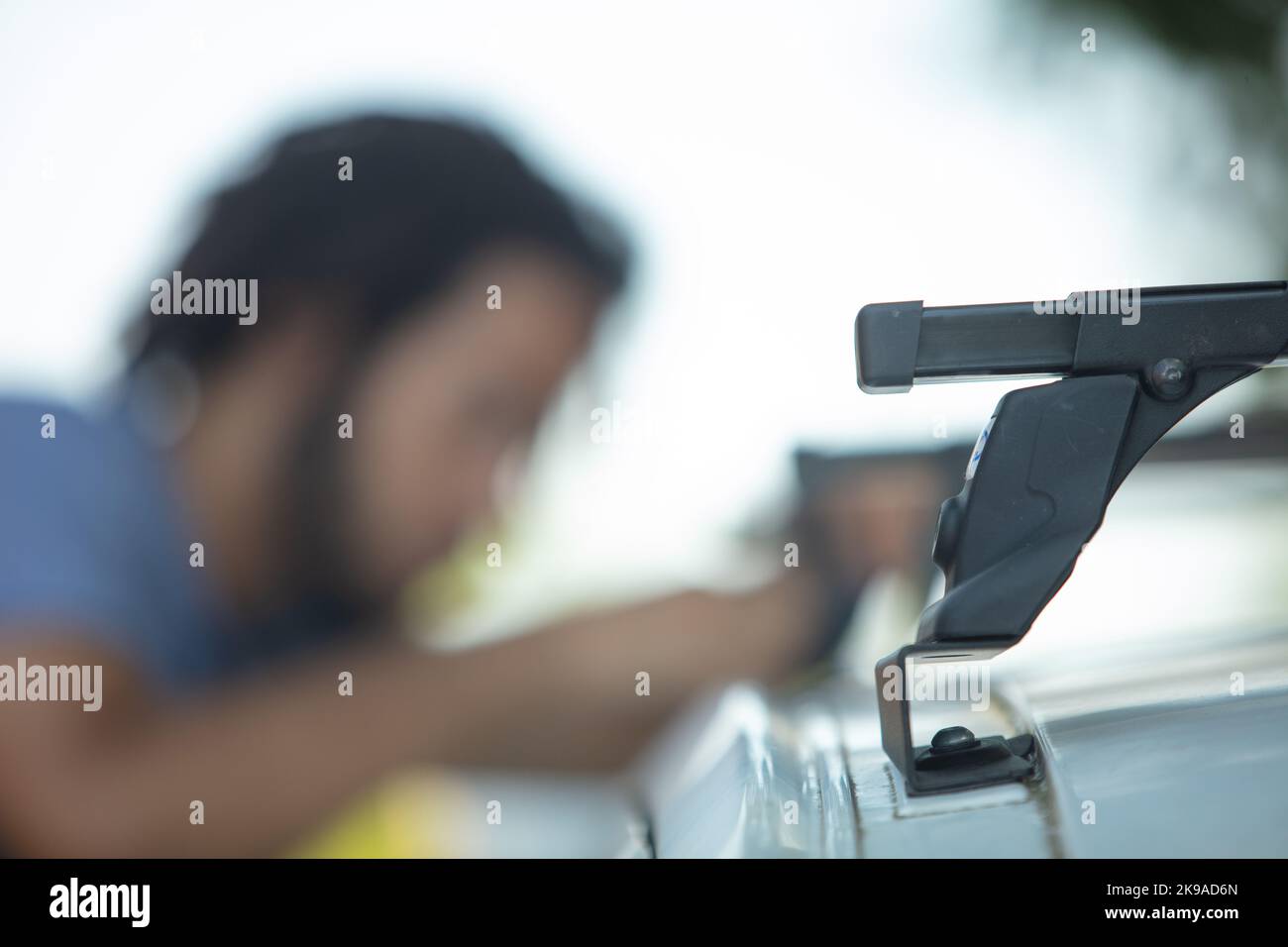 Mann, der Autogestelle auf dem Dach installiert Stockfoto
