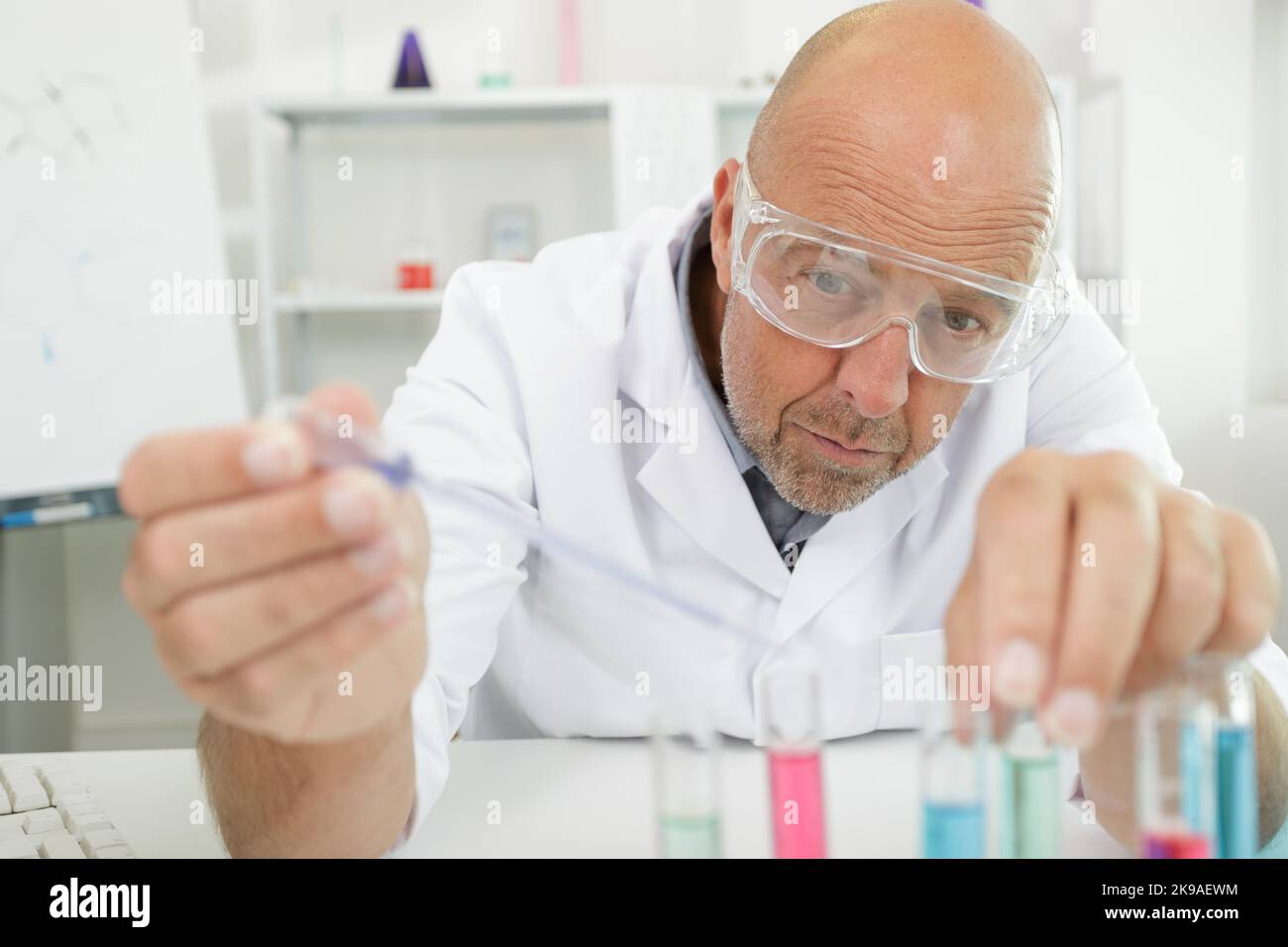 Senior Professor männlich Forscher testet eine chemische Flüssigkeit Rohre Stockfoto