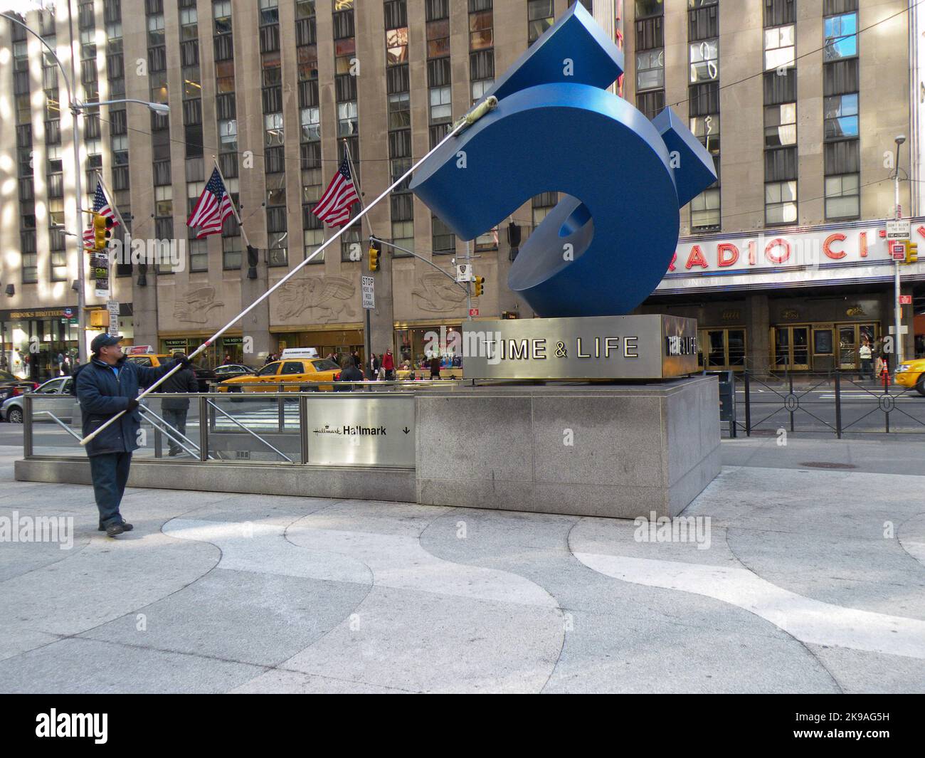 Ein Hausvater reinigt die Skulptur außerhalb des Time & Life-Gebäudes auf der 6. Avenue & 50. Street in Manhattan. Seitdem sind sie in die Innenstadt gezogen. Stockfoto