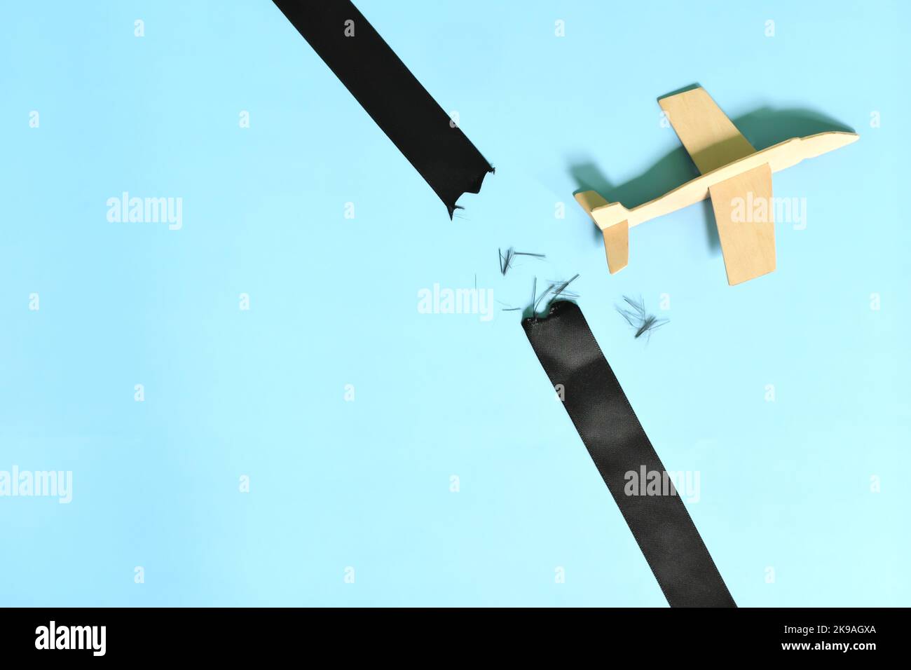 Das Geschäftskonzept durchbricht Barrieren und Grenzen. Flugzeugmodell durchbrechen eine schwarze Barriere auf blauem Hintergrund. Stockfoto