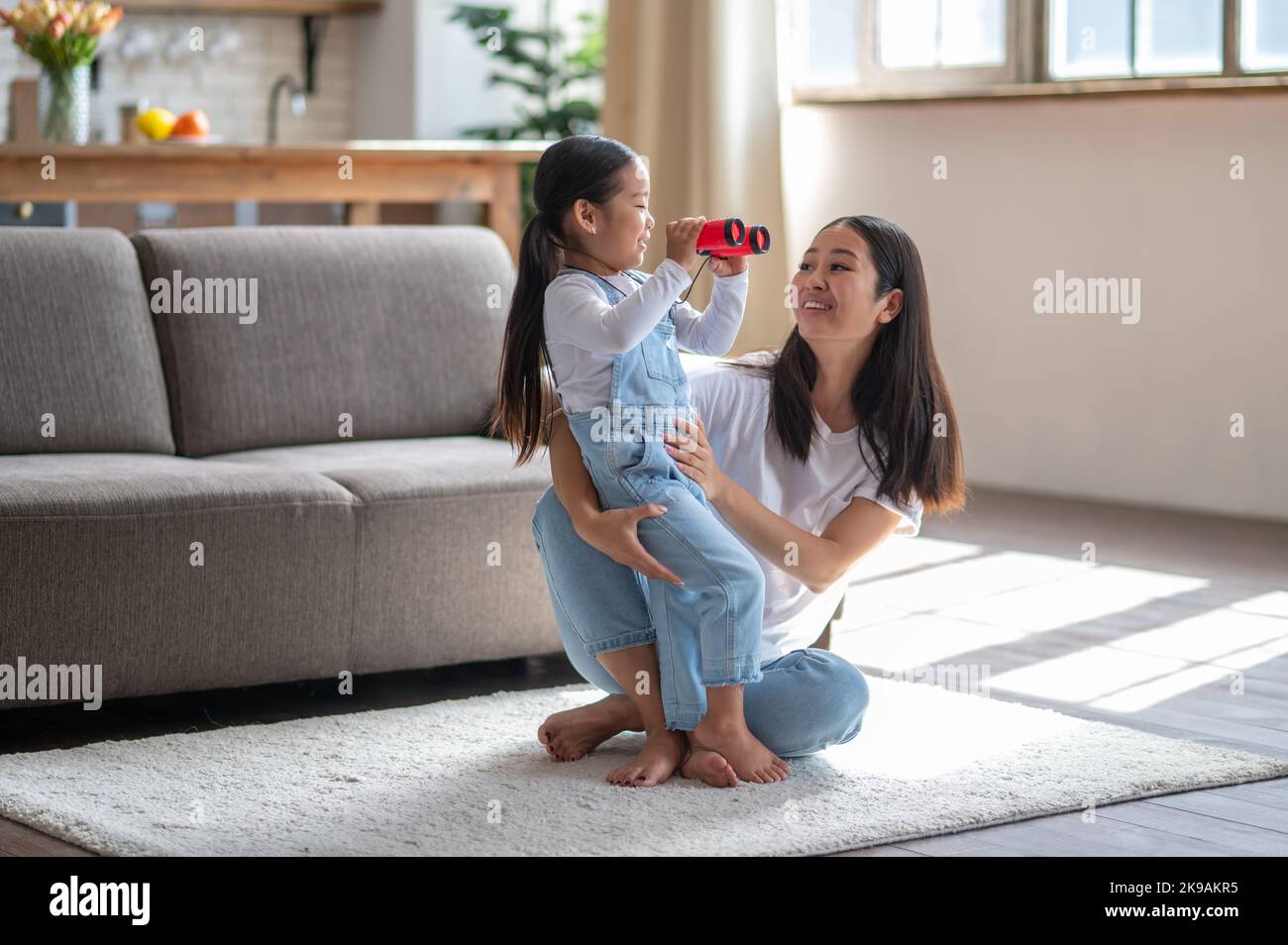 Liebevolle weibliche Eltern verbringen Zeit mit ihrem neugierigen Kind Stockfoto