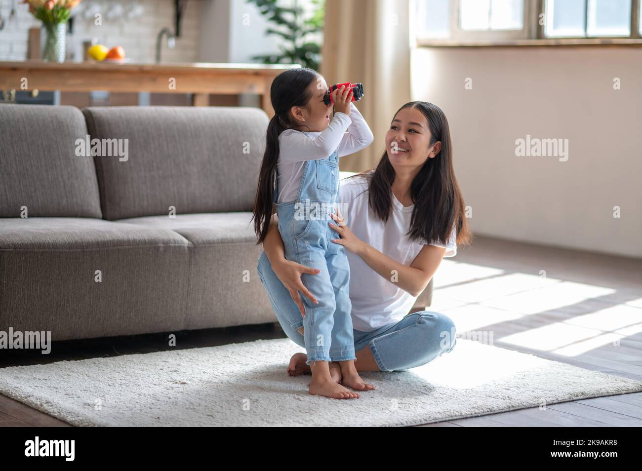 Frau genießt die Gesellschaft ihrer neugierigen Tochter Stockfoto