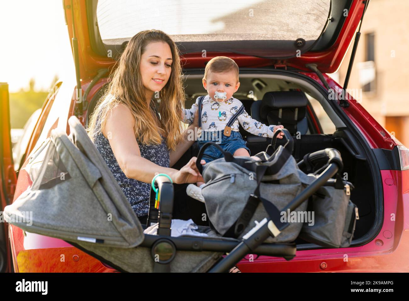 Mutter mit ihrem Sohn hinter dem Wagen, der die Reise vorbereitete Stockfoto