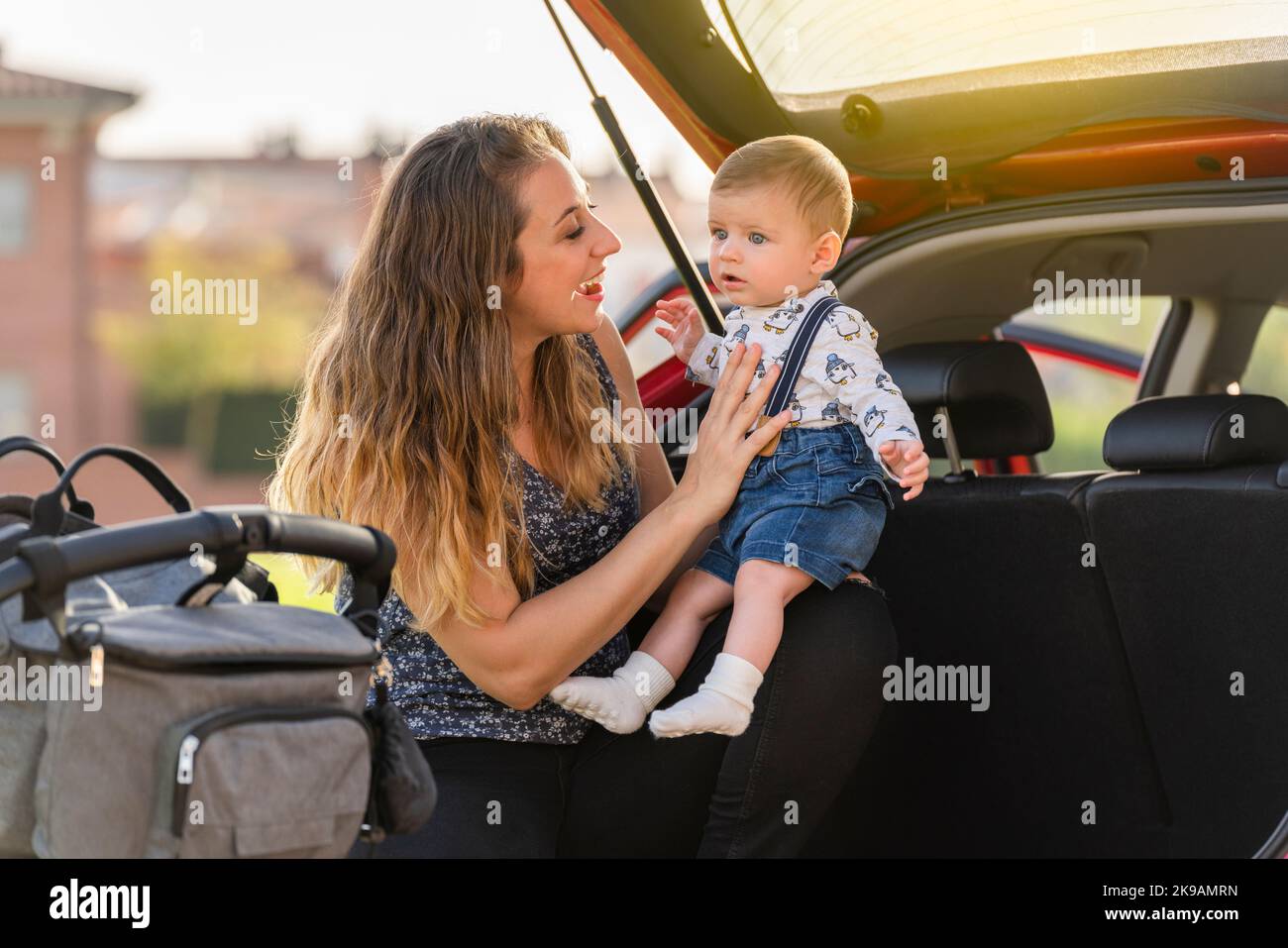 Mutter mit ihrem Sohn hinter dem Wagen, der die Reise vorbereitete Stockfoto
