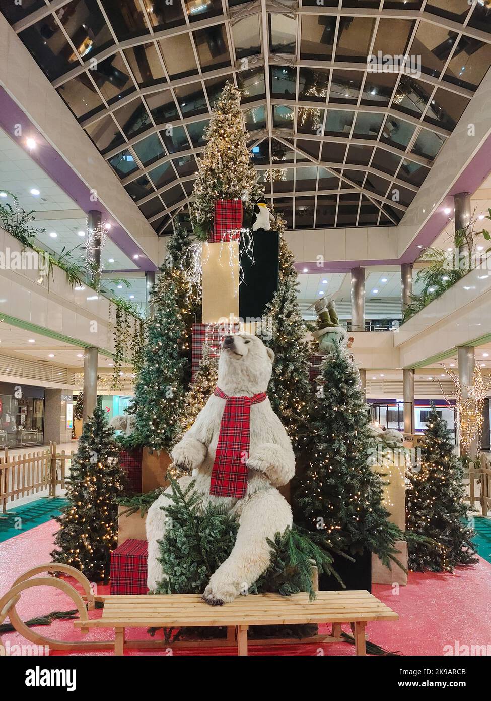 Riesiger Weihnachtsbaum mit weißem Bär und Schlitten in einem Einkaufszentrum Stockfoto